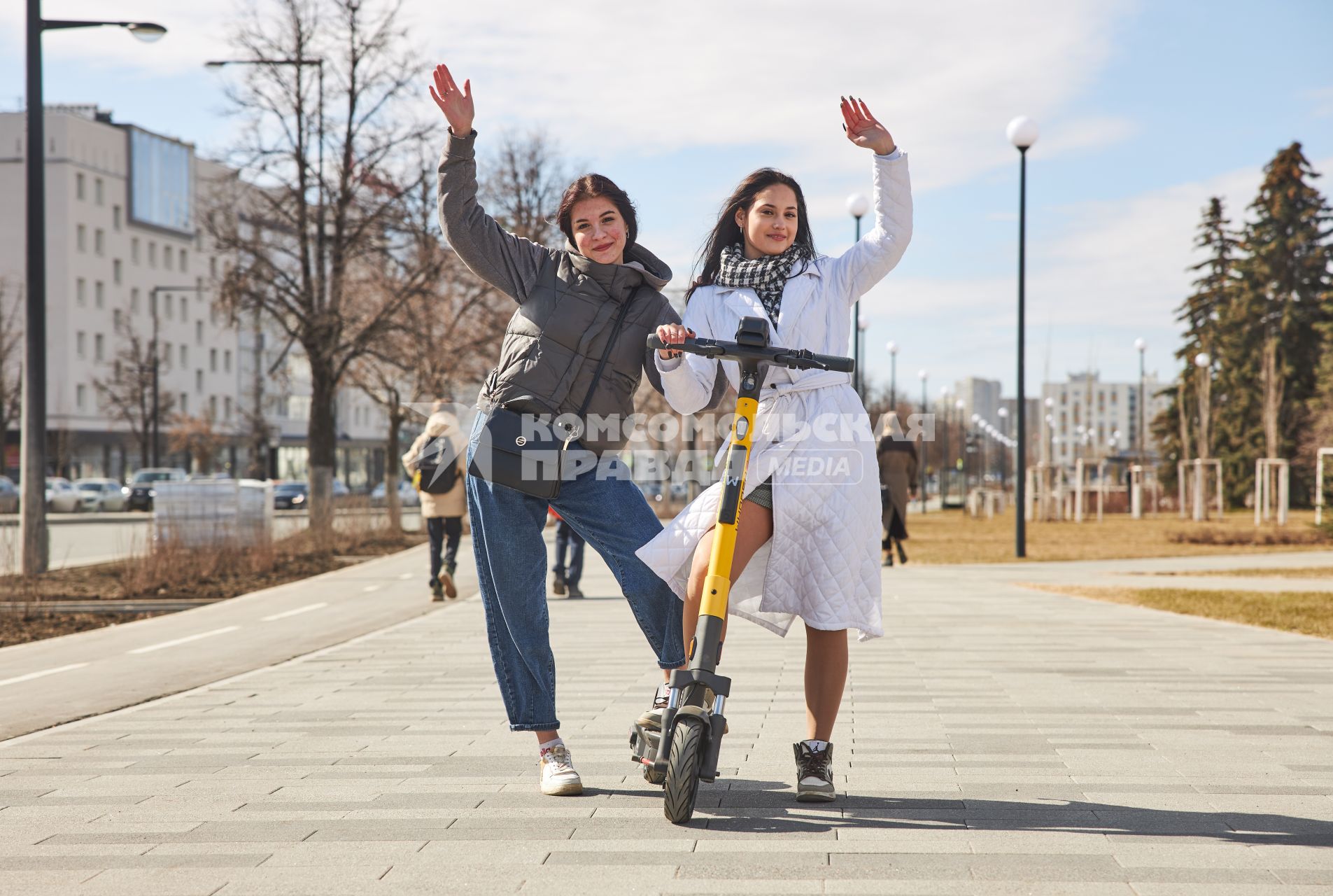 Пермь. Девушки с электросамокатом стоят рядом с  выделенной полосой для самокатов и велосипедов.