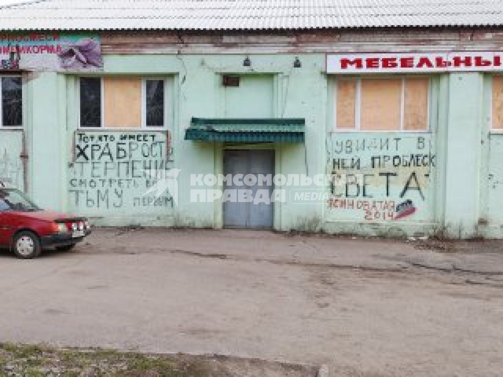 Донецкая область. г.Ясиноватая. Надписи на фасаде мебельного магазина,  где часть окон выбиты и закрыты фанерой.