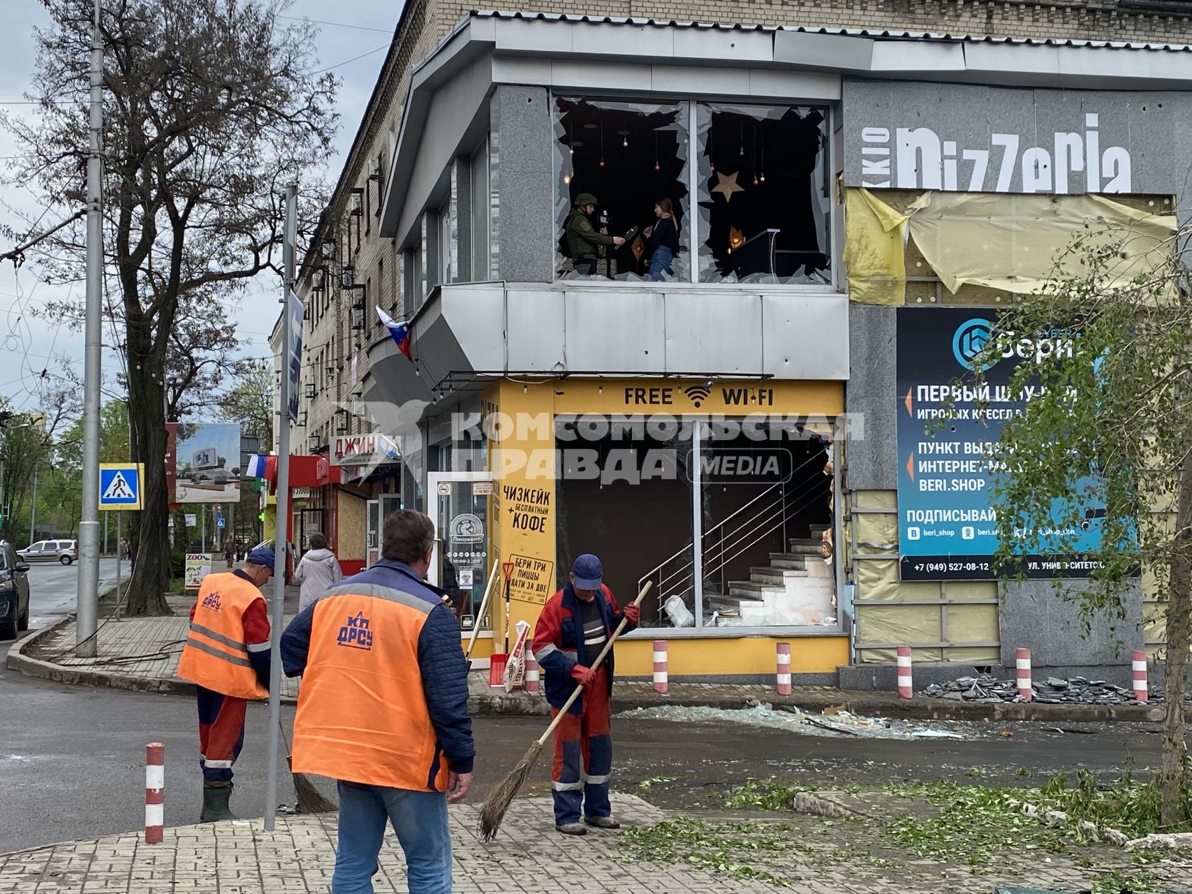 Донецк. Коммунальщики убирают разбитые стекла у ТЦ, пострадавшего в результате обстрела ВСУ.