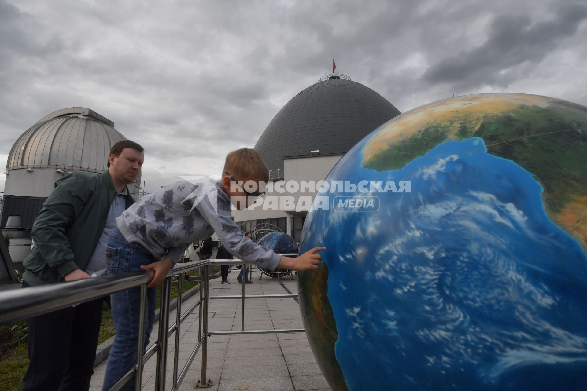 Москва. Астрономическая площадка `Парк неба` Московского планетария. Посетители у Глобуса Набокова - модели земного шара.