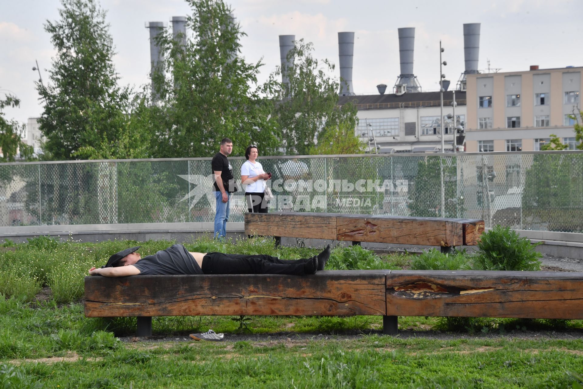 Москва. Мужчина спит на скамейке в парке `Зарядье`.