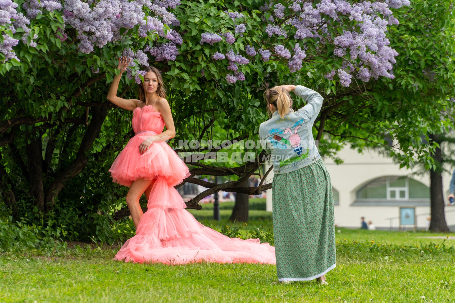Москва. Девушки фотографируются у цветущей  сирени в музее-заповеднике `Коломенское`.