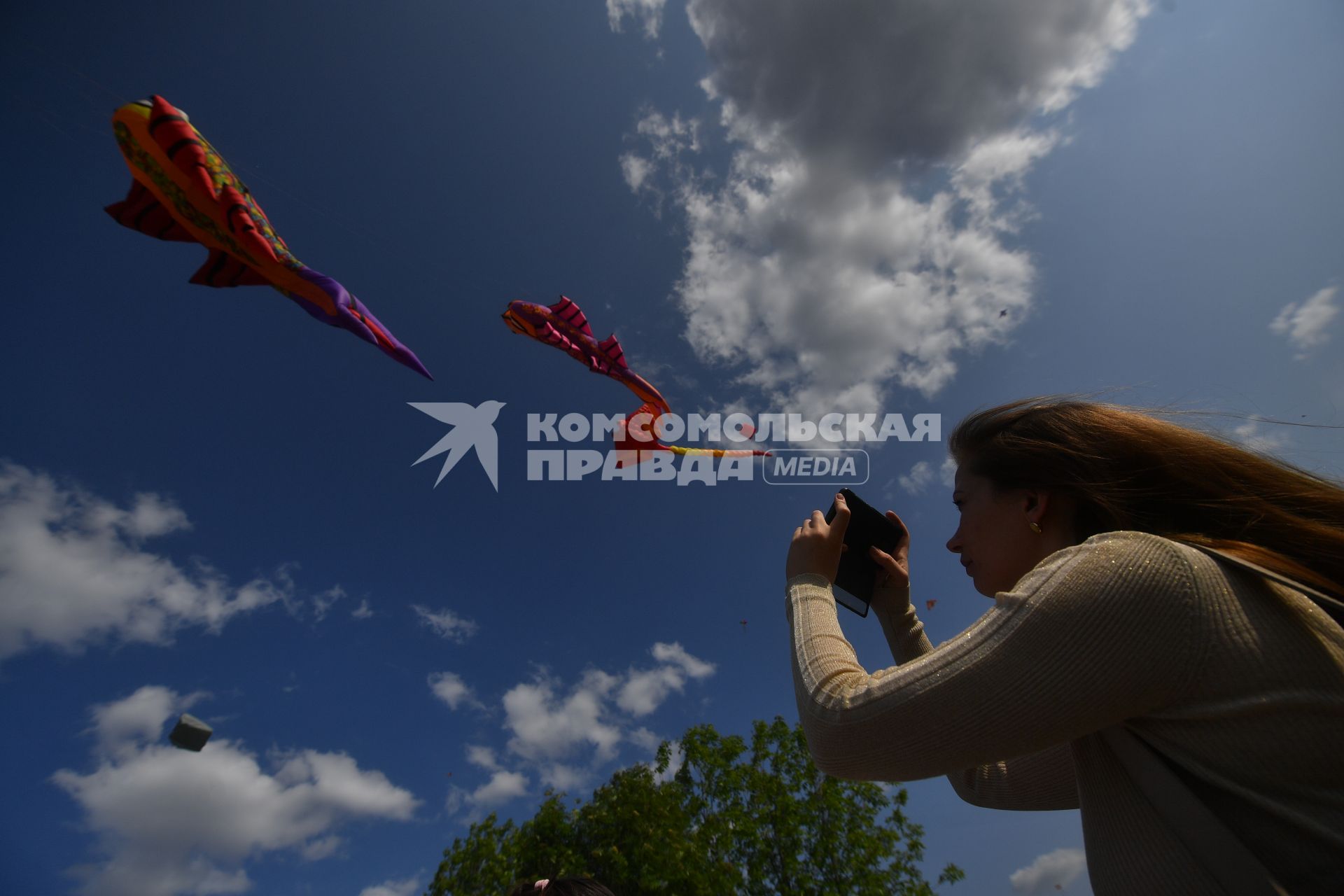 Москва.  Девушка фотографирует воздушные змеи во время фестиваля `Пестрое небо` в музее-заповеднике `Царицыно`.