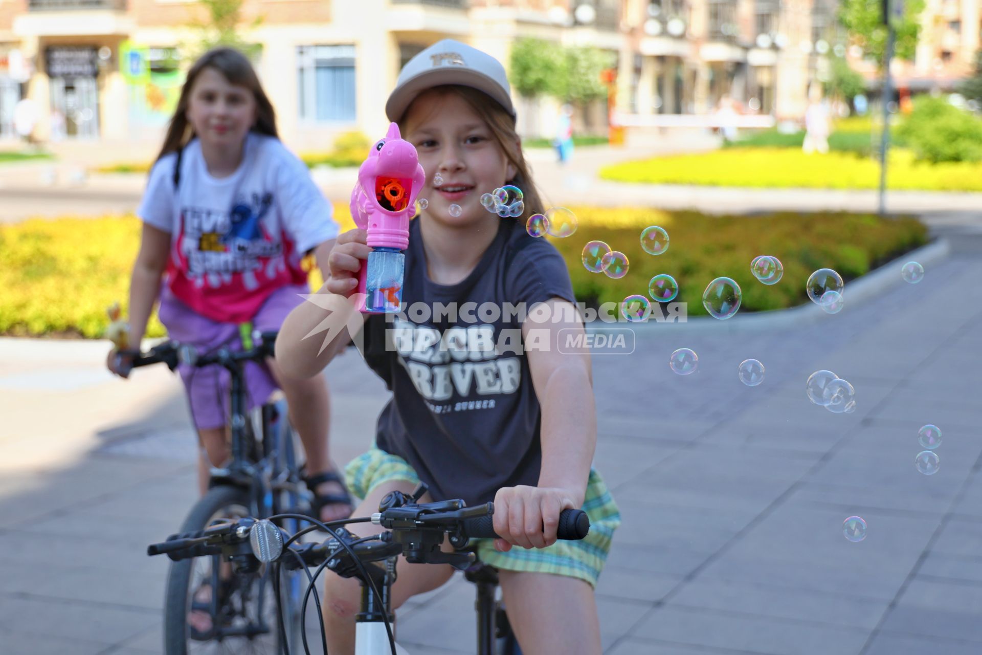 Красноярск. Девочка едет на велосипеде и пускает мыльные пузыри во время празднования Дня защиты детей в микрорайоне `Южный берег`.