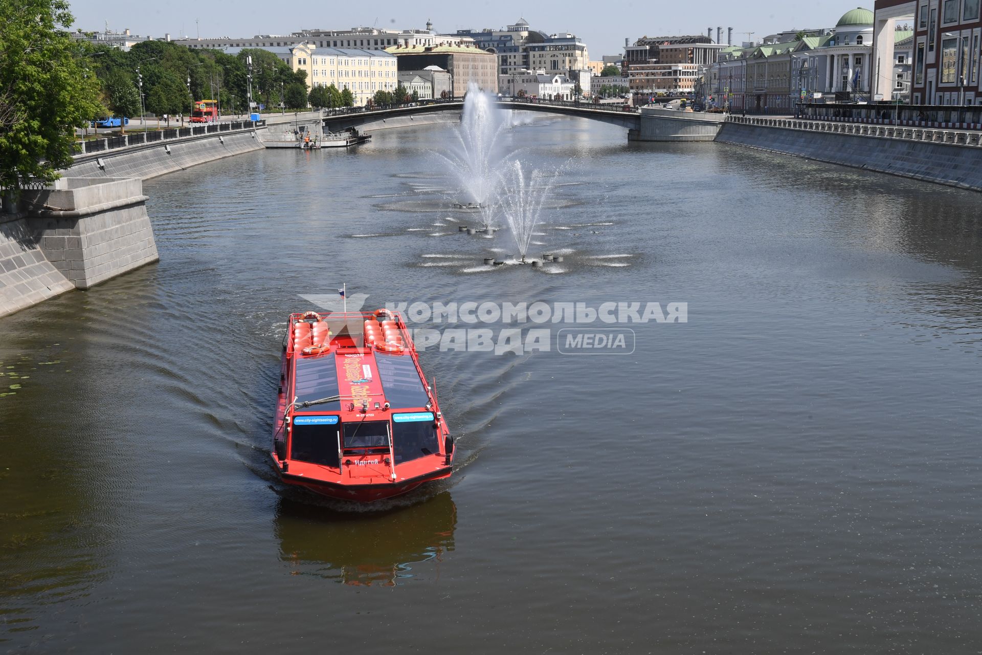 Москва. Прогулочный катер плывет мимо плавающих фонтанов на Водоотводном канале возле пешеходного Третьяковского моста в районе Кадашевской и Болотной набережных.
