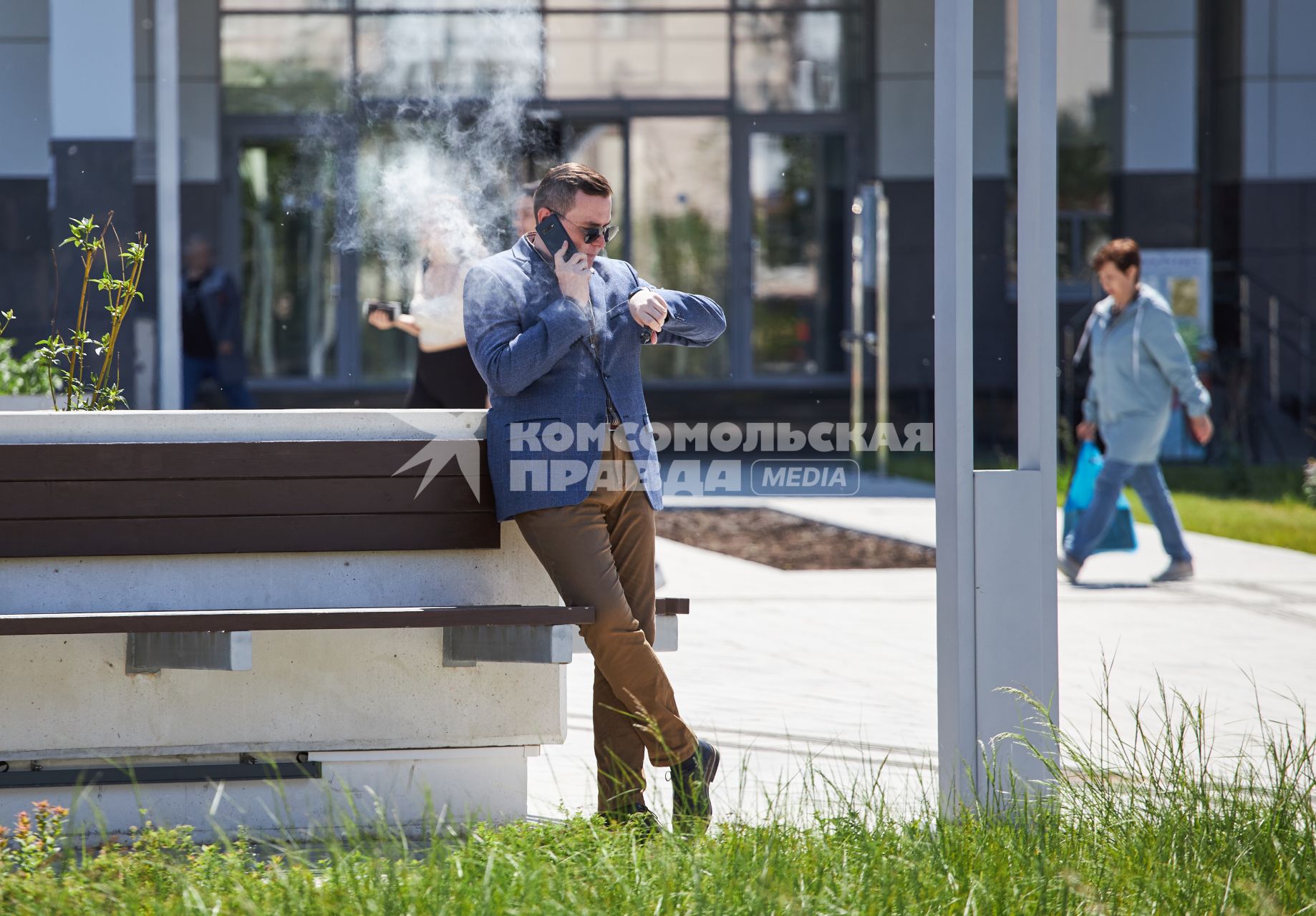 Пермь. Мужчина с мобильным телефоном курит на улице.
