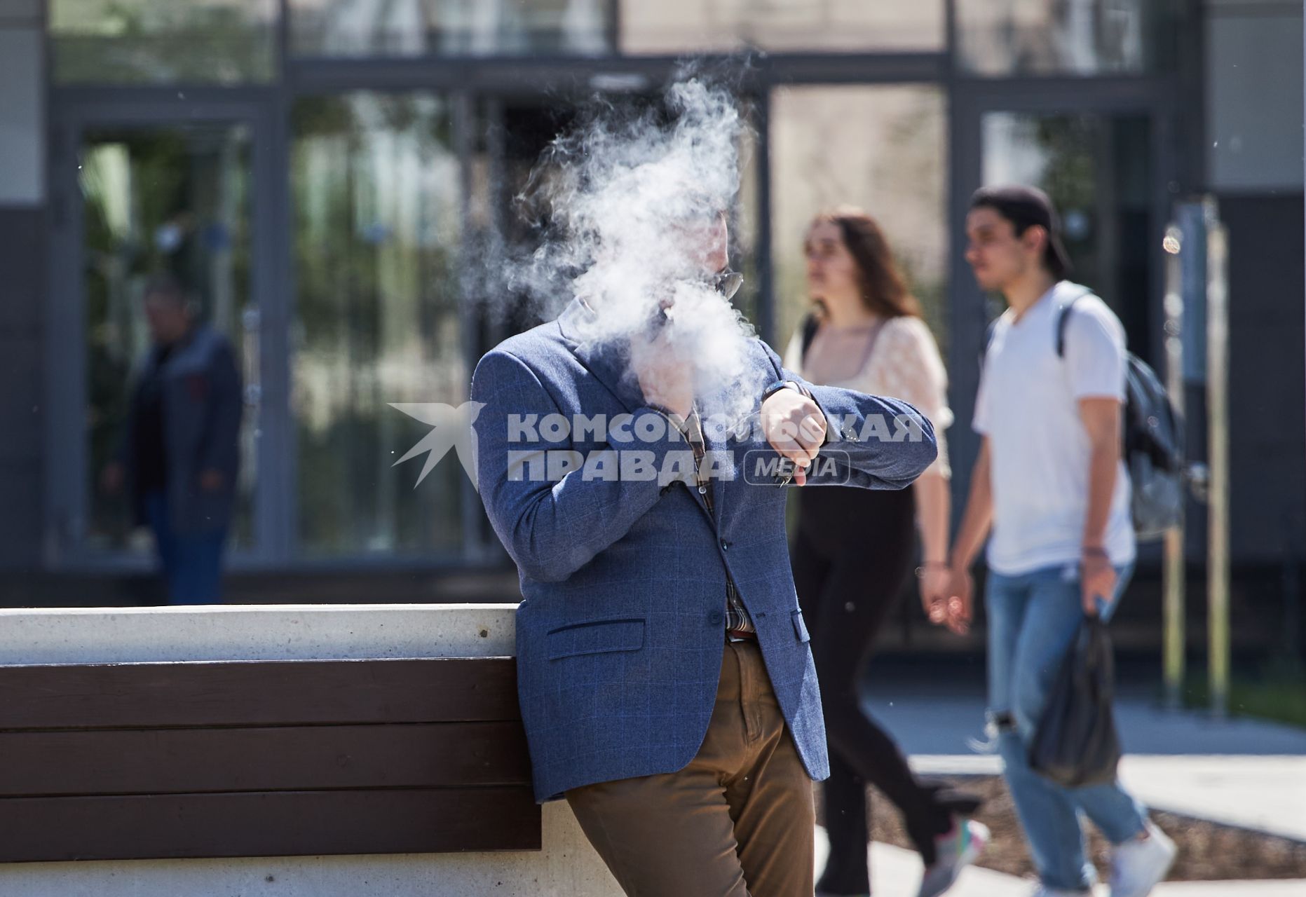 Пермь. Мужчина с мобильным телефоном курит на улице.