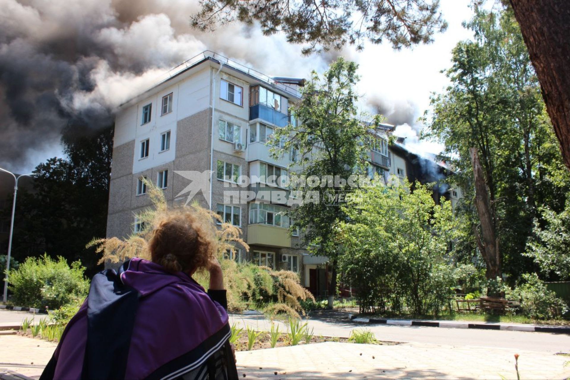 Белгородская область. г.Шебекино. Девушка смотрит на дымящийся жилой дом, обстрелянный артиллерией ВСУ.