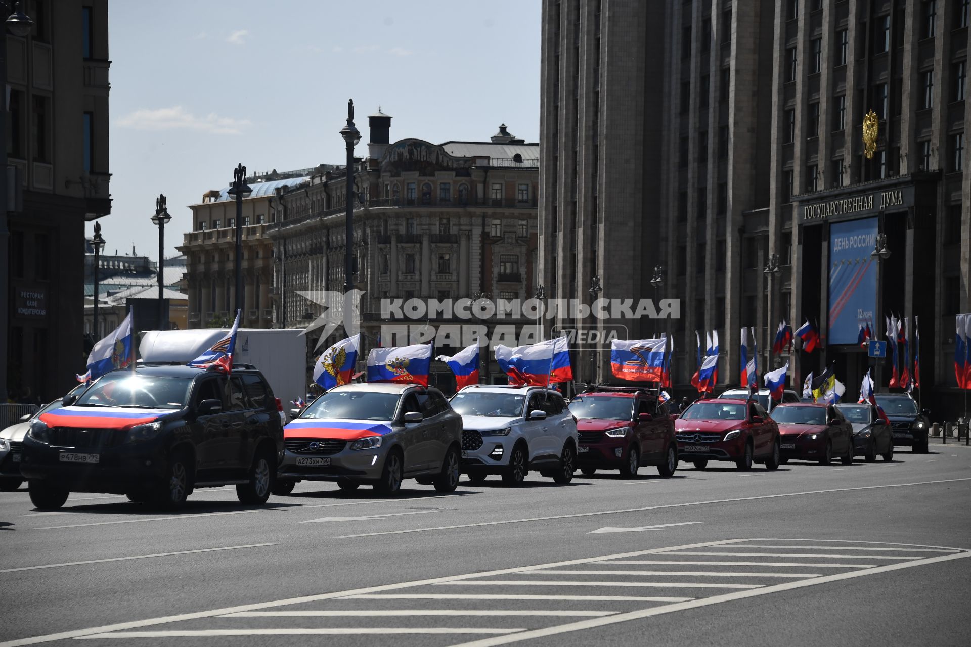 Москва. Колонна машин с  флагами России у здания Государственной Думы РФ  в день празднования Дня России.