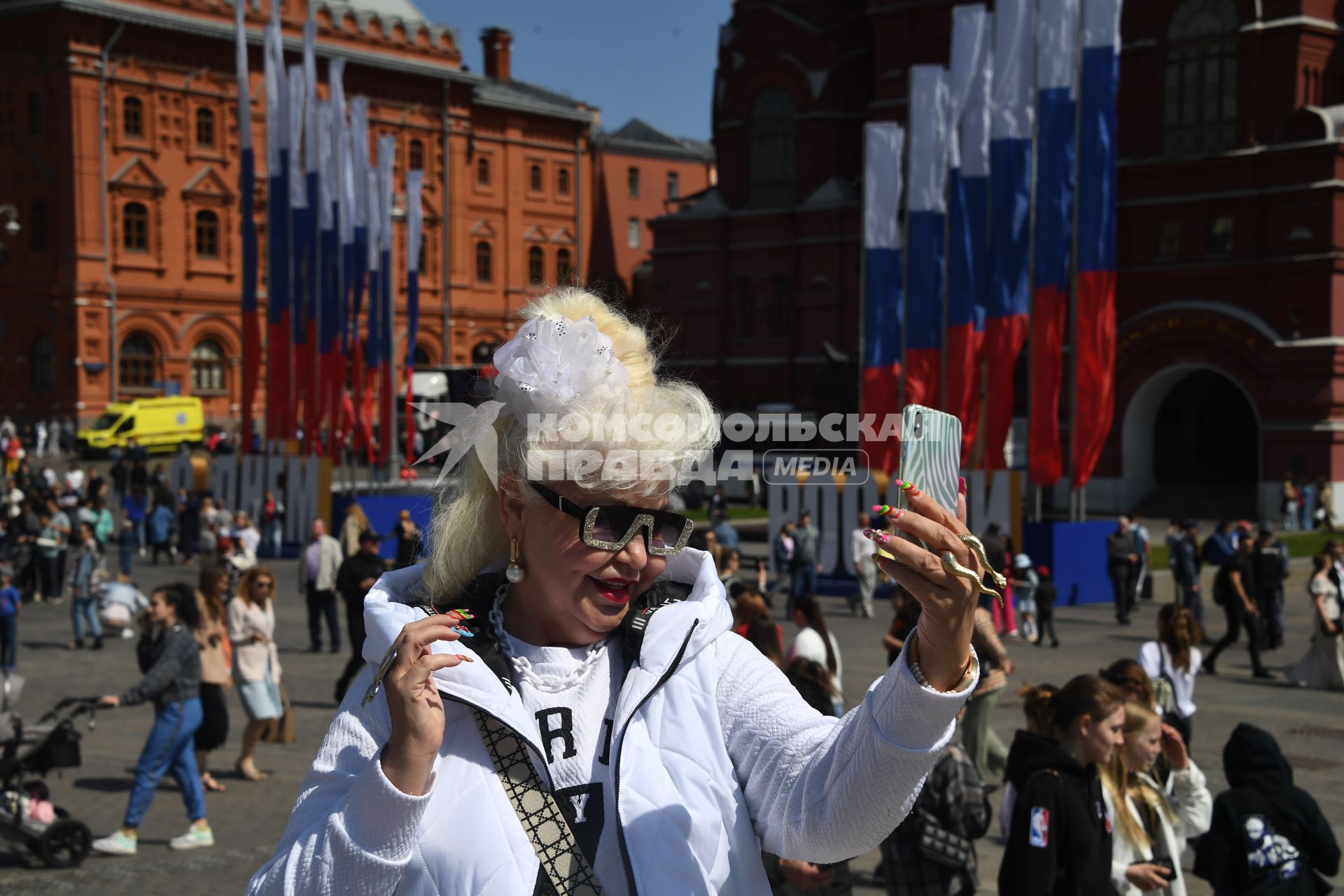 Москва. Женщина фотографирует на Манежной площади  в День празднования Дня России.