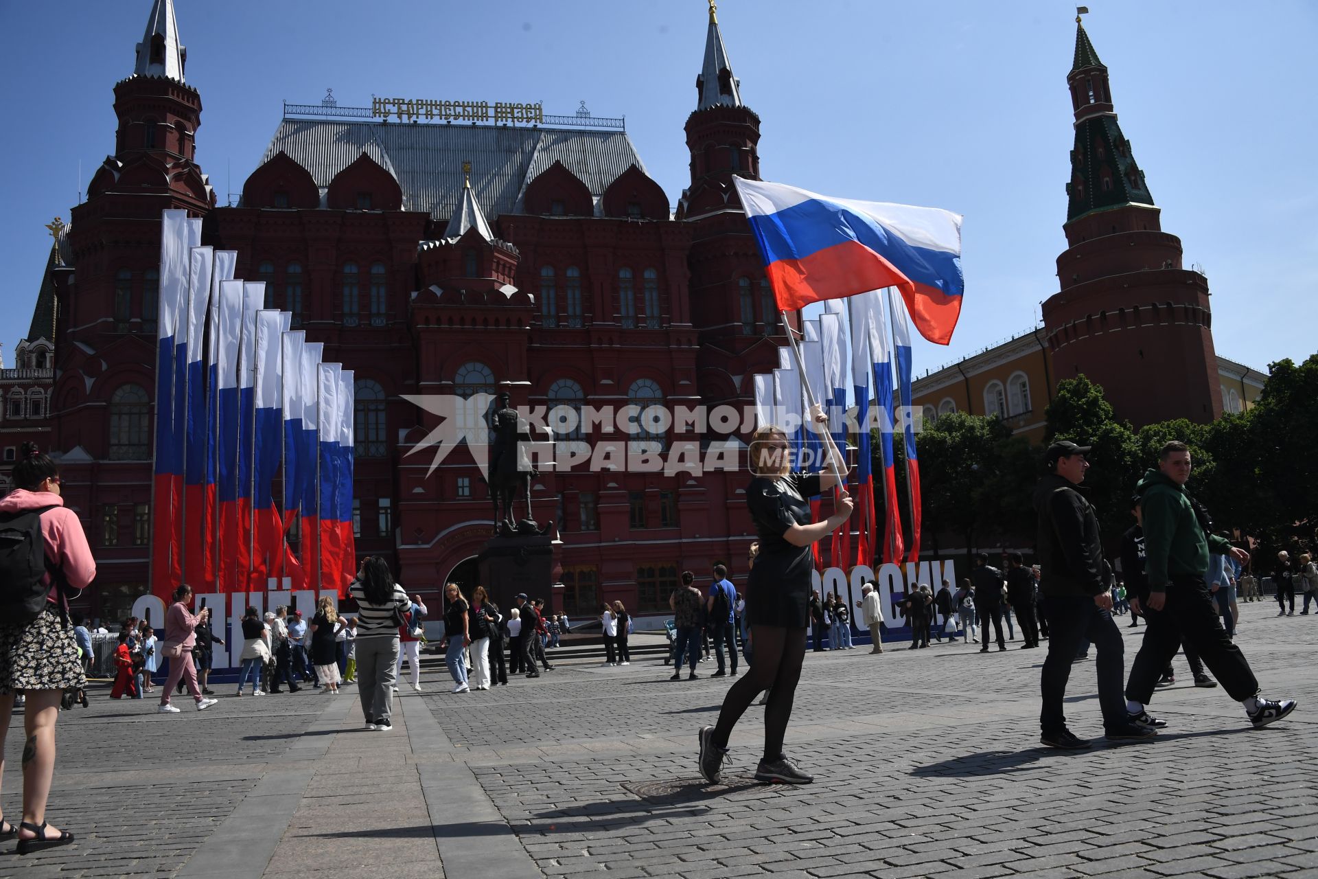 Москва.  Женщина с Российским флагом на Манежной площади  в День празднования Дня России.