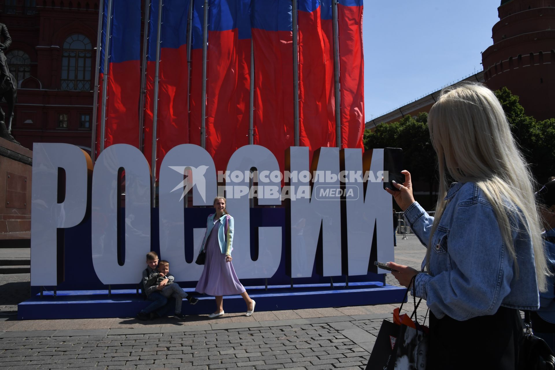 Москва. Женщина фотографирует на Манежной площади  в День празднования Дня России.
