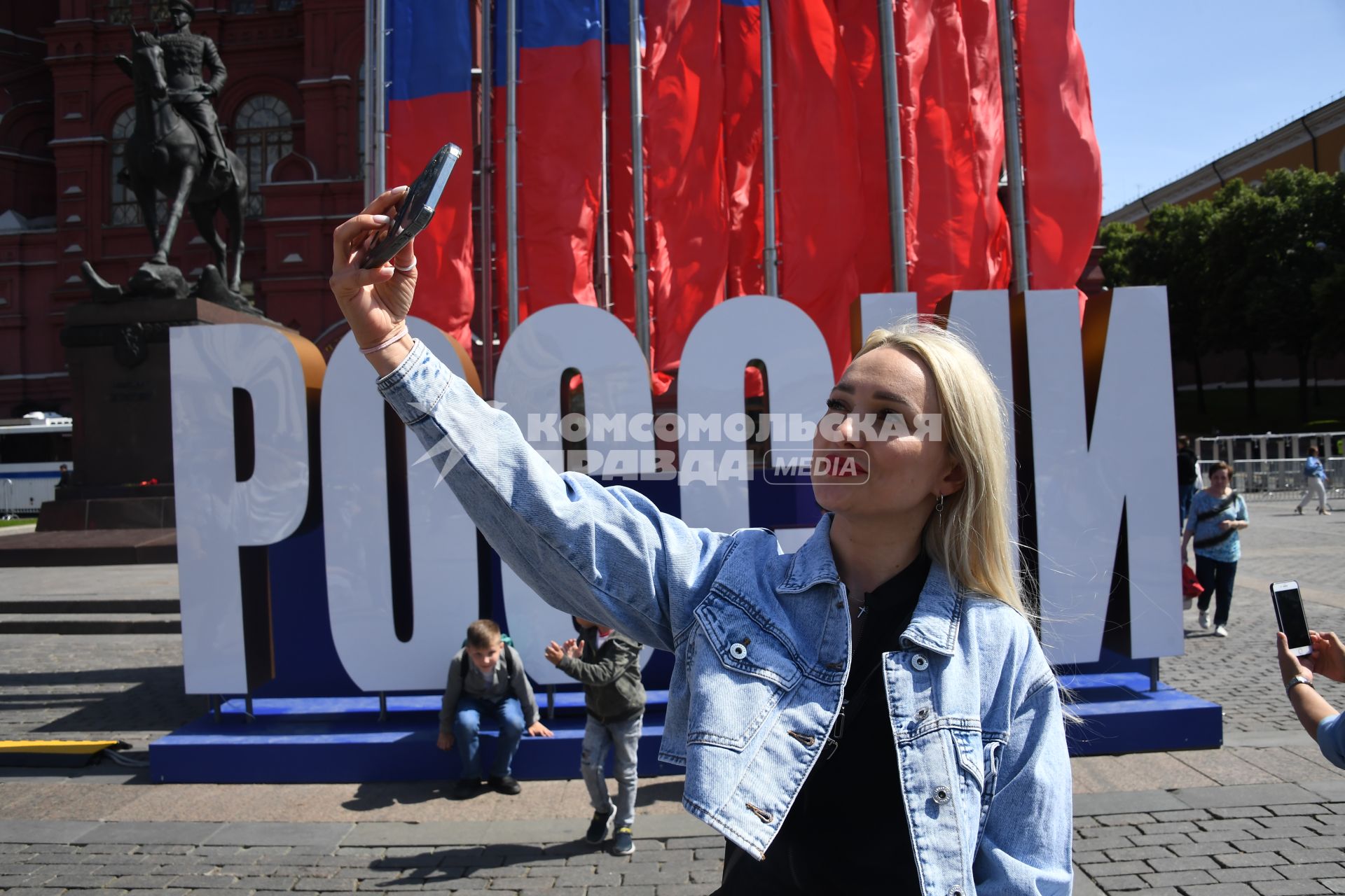 Москва. Женщина фотографирует на Манежной площади  в День празднования Дня России.