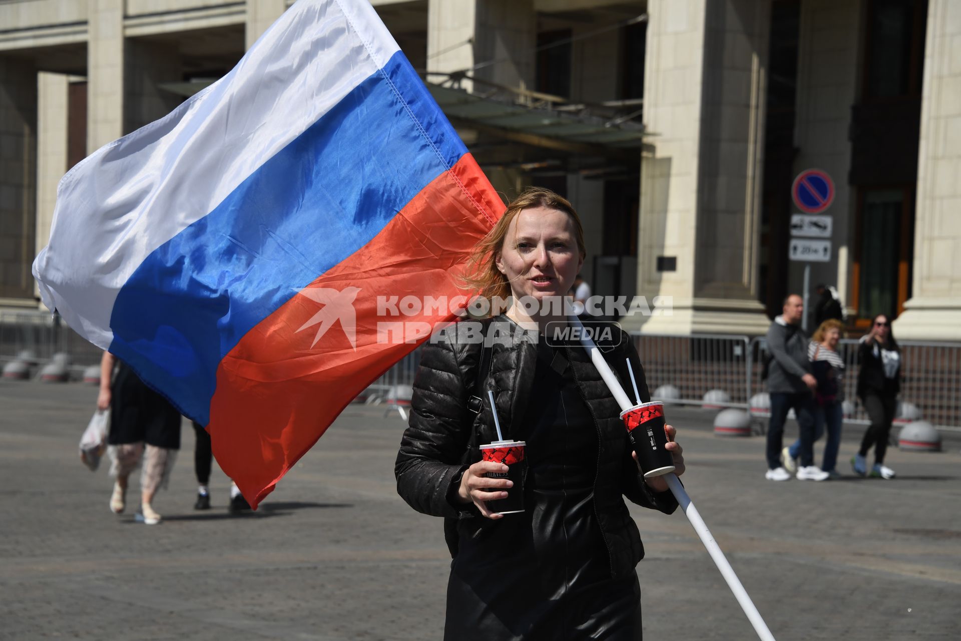 Москва.  Женщина с Российским флагом на Манежной площади  в День празднования Дня России.