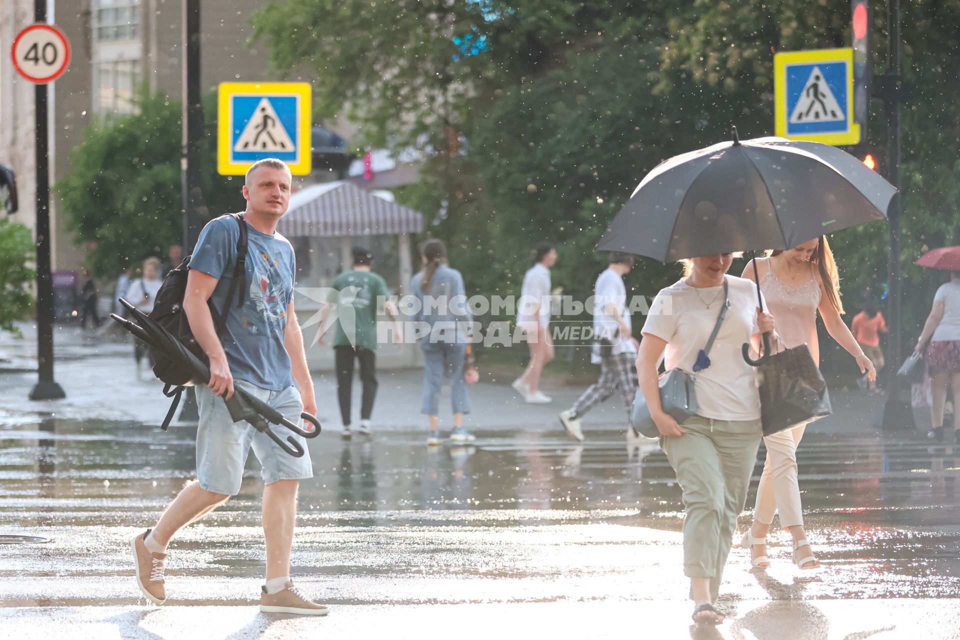 Красноярск. Люди переходят дорогу во время дождя.