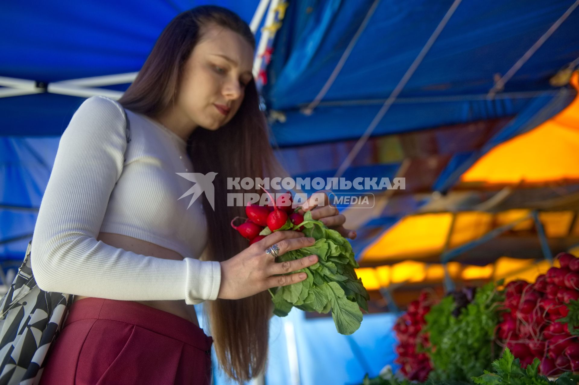 Екатеринбург. Девушка покупает фрукты, овощи и зелень на рынке. Редис