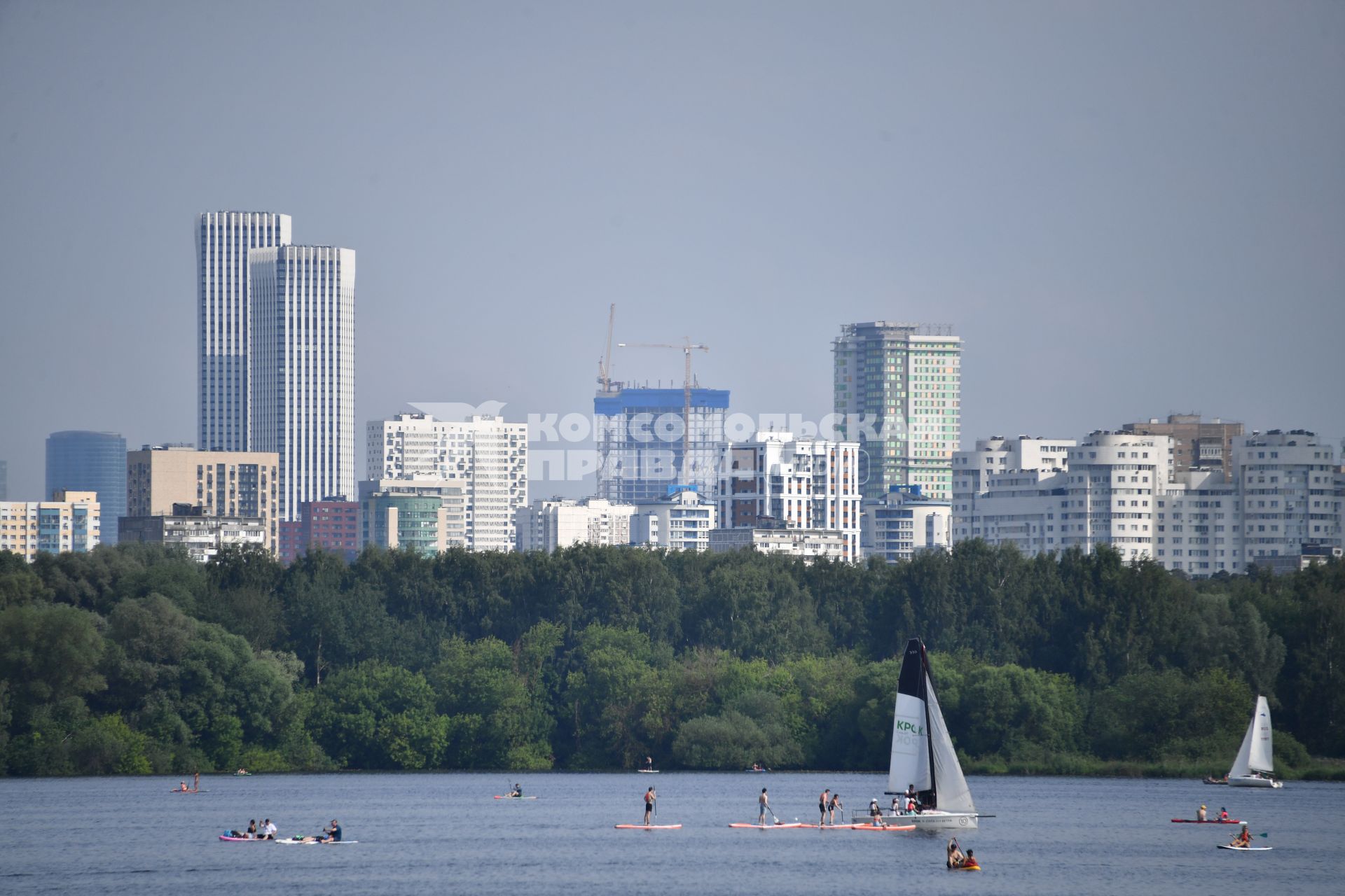 Москва. Люди плавают на sup-борде у пляжа в Строгино.