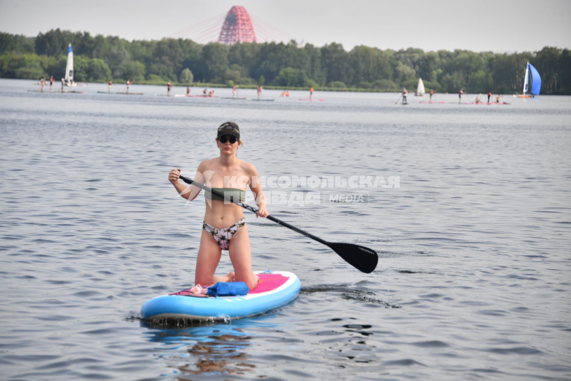 Москва. Девушка плывет на sup-борде у пляжа в Строгино.