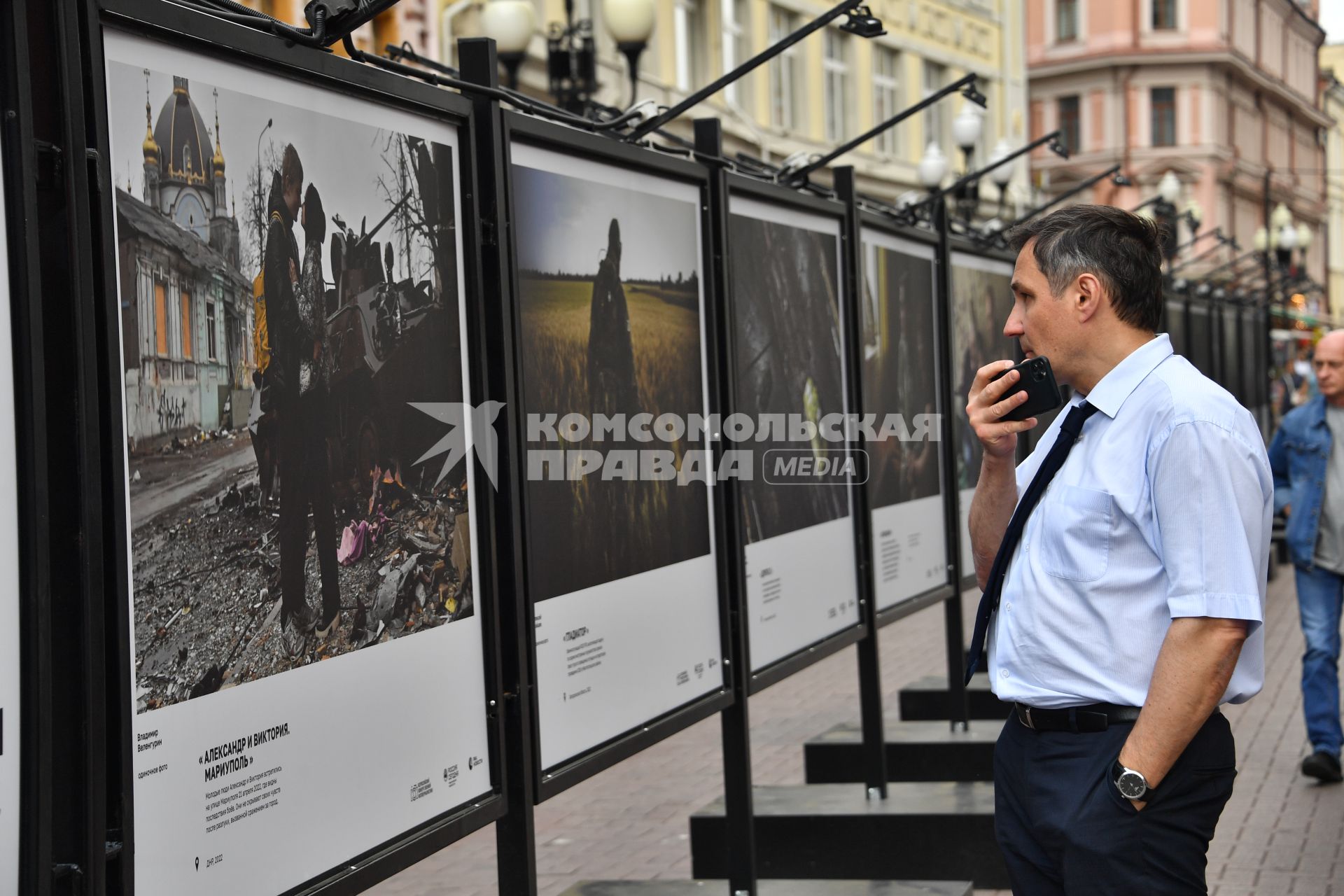 Москва. Мужчина у стендов с  фотографиями выставки лауреатов Всероссийского конкурса военной журналистики, которая открылась на Арбате.