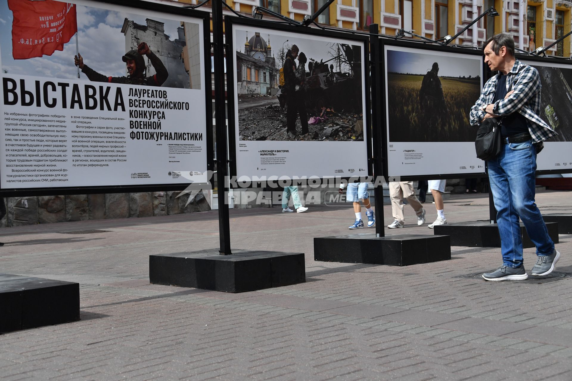 Москва. Мужчина у стендов с  фотографиями выставки лауреатов Всероссийского конкурса военной журналистики, которая открылась на Арбате.