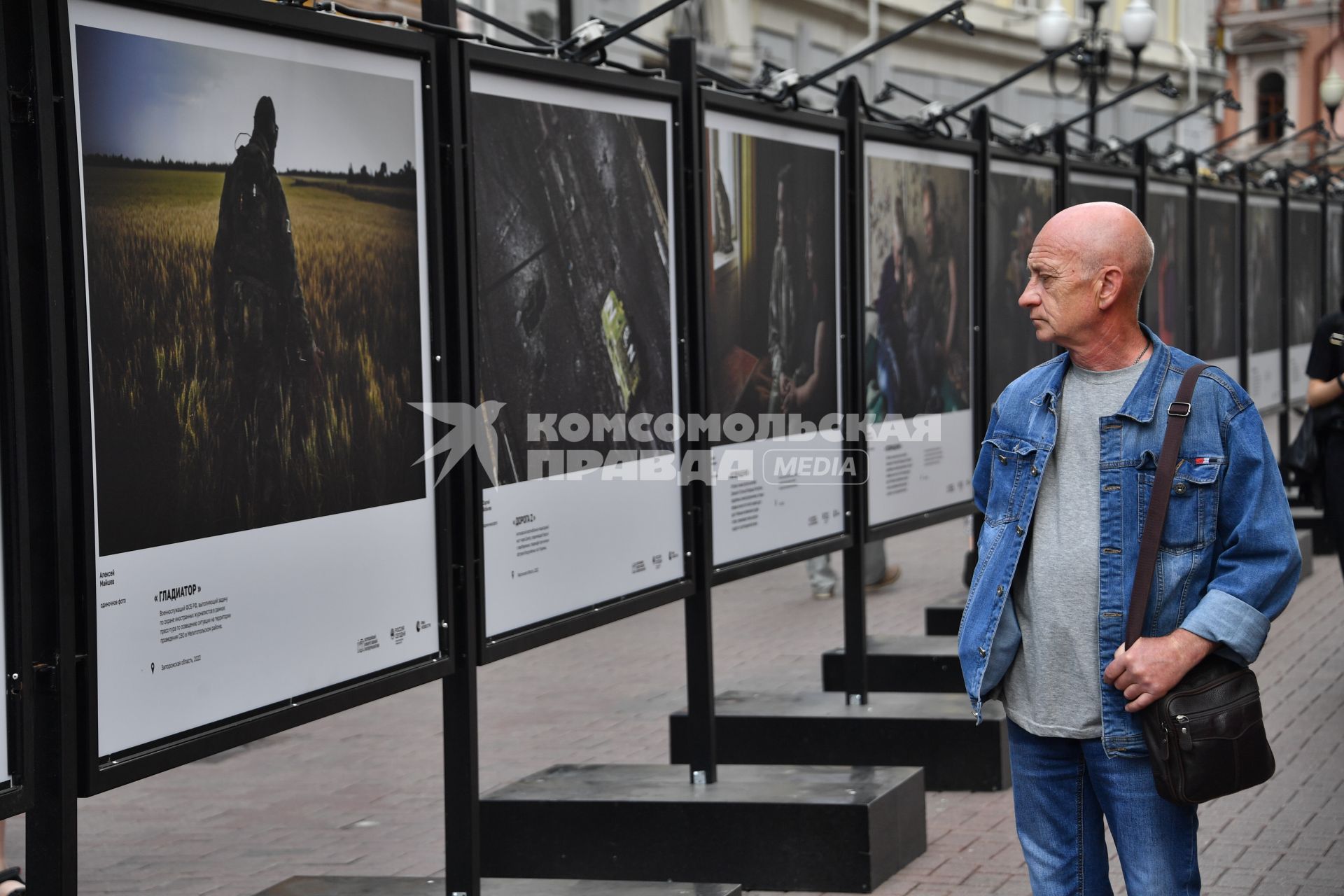 Москва. Мужчина у стендов с  фотографиями выставки лауреатов Всероссийского конкурса военной журналистики, которая открылась на Арбате.