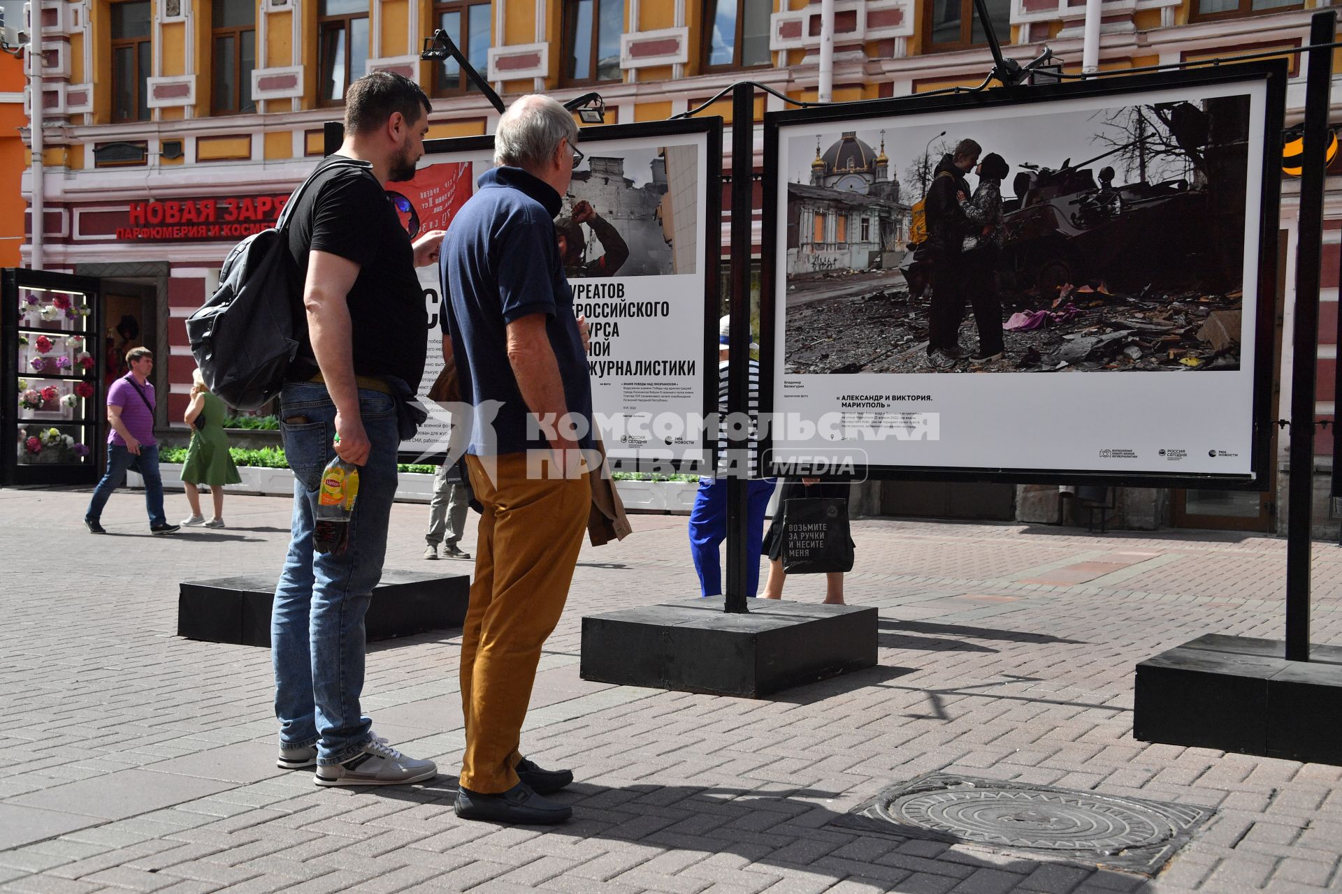 Москва. Прохожие у стендов с  фотографиями выставки лауреатов Всероссийского конкурса военной журналистики, которая открылась на Арбате.