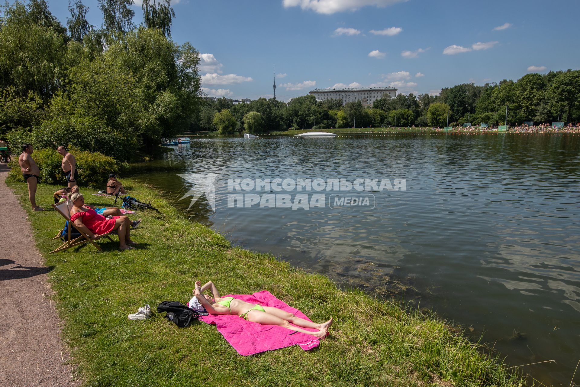 Москва. Горожане загорают на берегу Путяевского пруда в парке Сокольники.