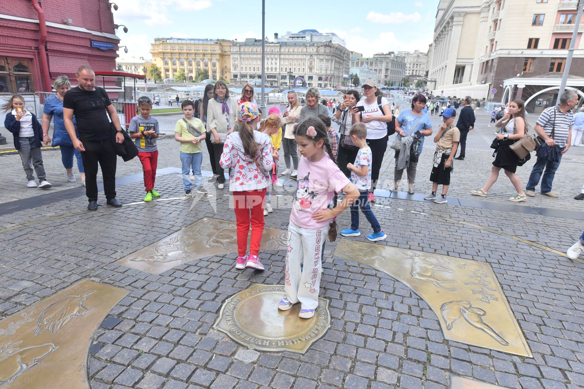 Москва. Девочка стоит на Нулевом километре всех дорог России  на Манежной площади, у Воскресенских ворот и  Иверской часовни.