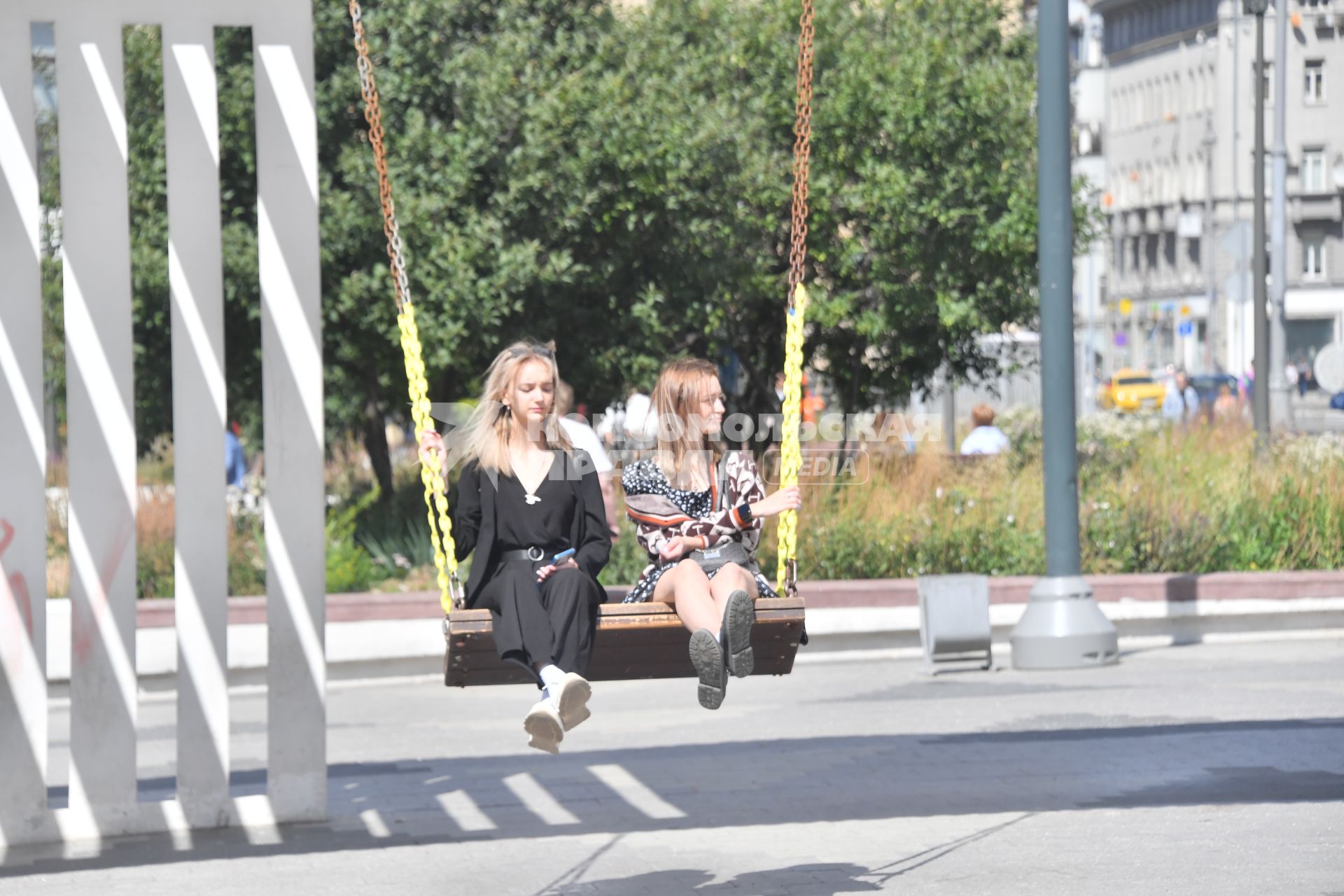 Москва. Девушки отдыхают на качелях у метро  Маяковская.