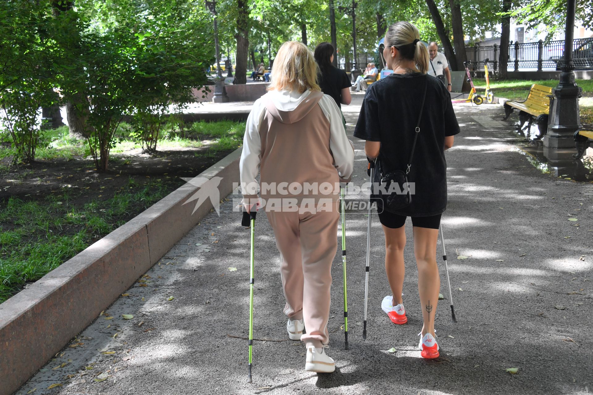Москва. Женщины с палками для скандинавской ходьбы на бульваре.