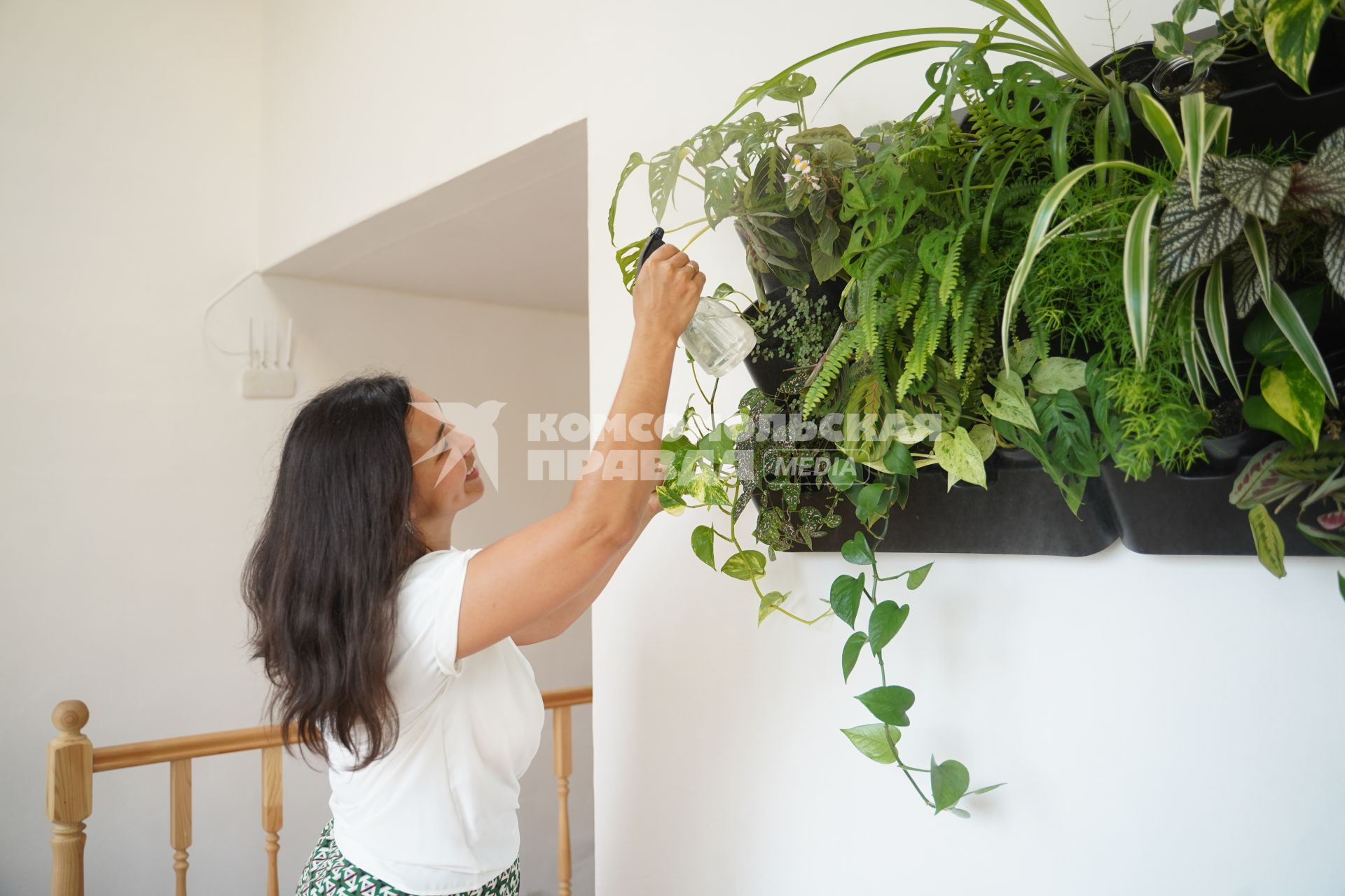 Самара. Девушка ухаживает за комнатными растениями.