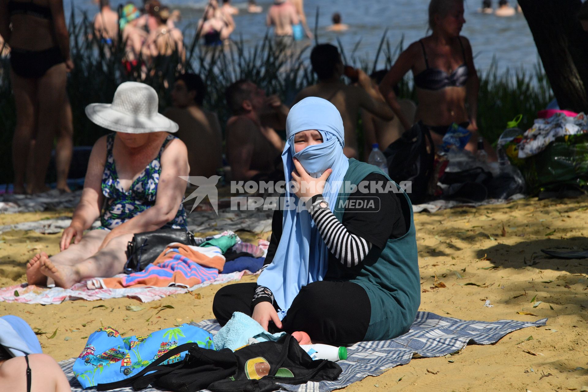 Москва. Мусульманка загорает на пляже озера Белое в районе Косино-Ухтомское.