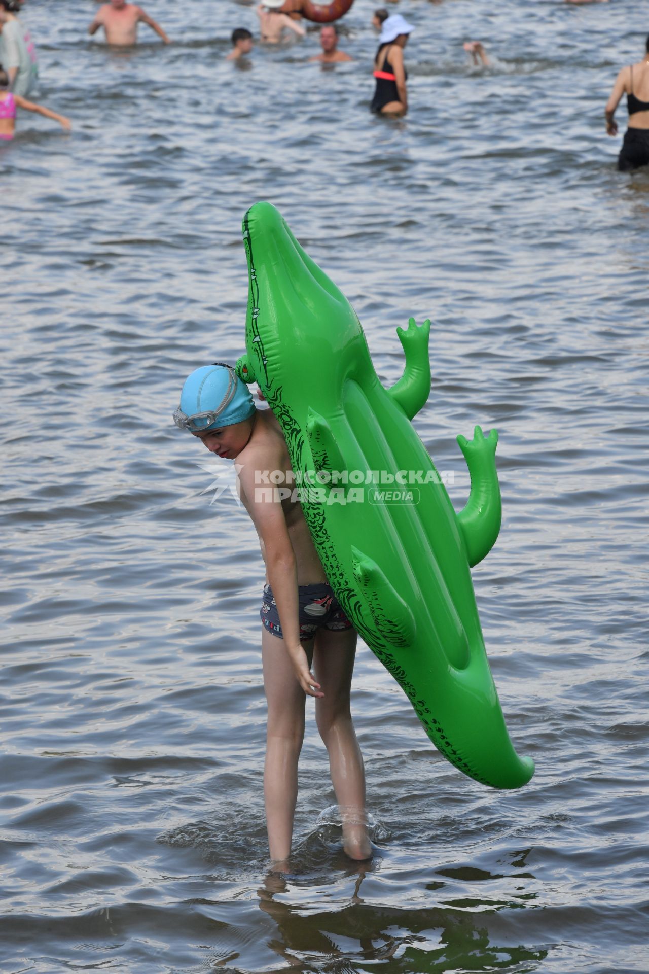 Москва. Мальчик с надувным крокодилом купается в озере Белое в районе Косино-Ухтомское.