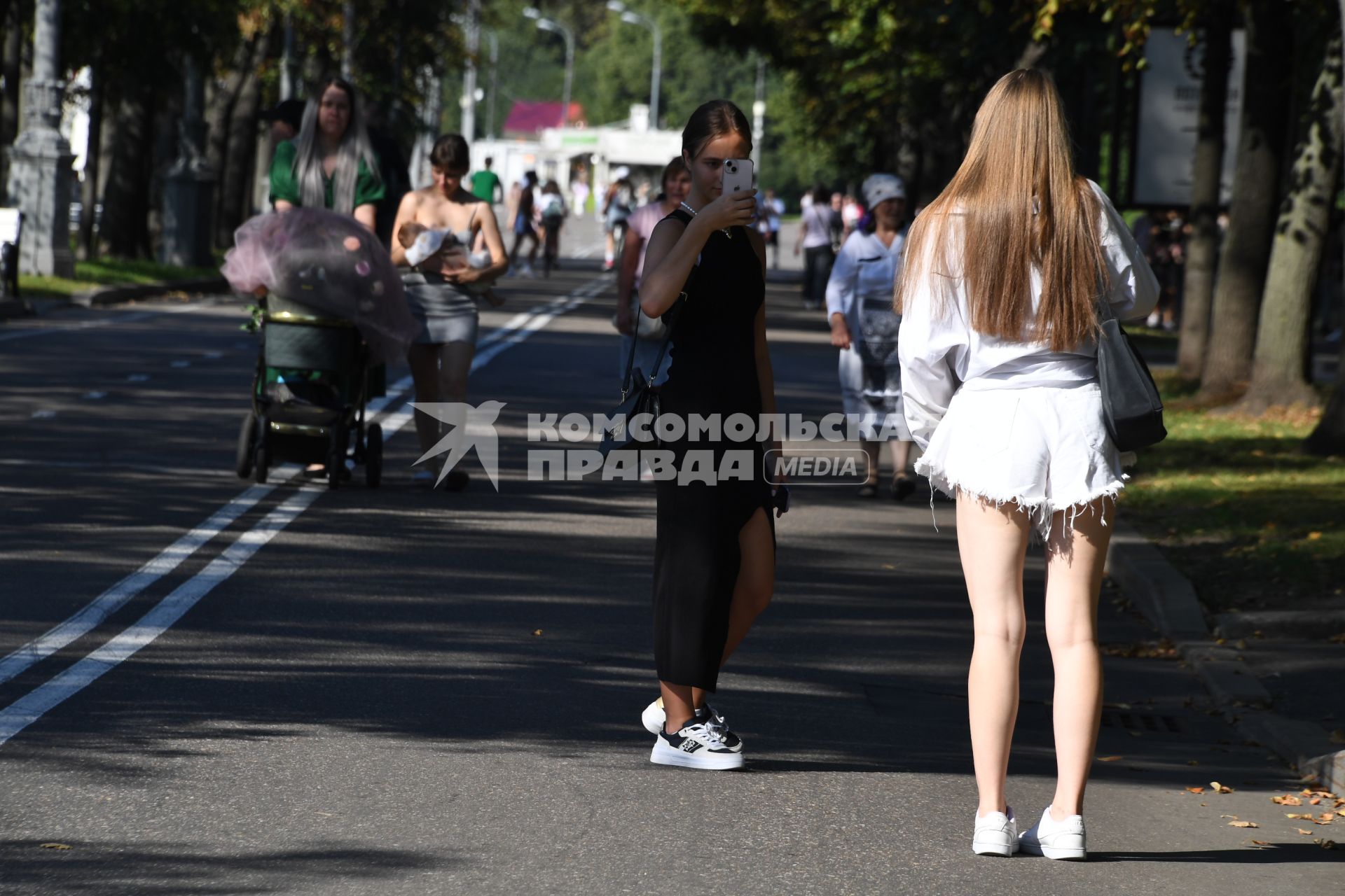 Москва.   Горожане в жаркий день гуляют в парке.