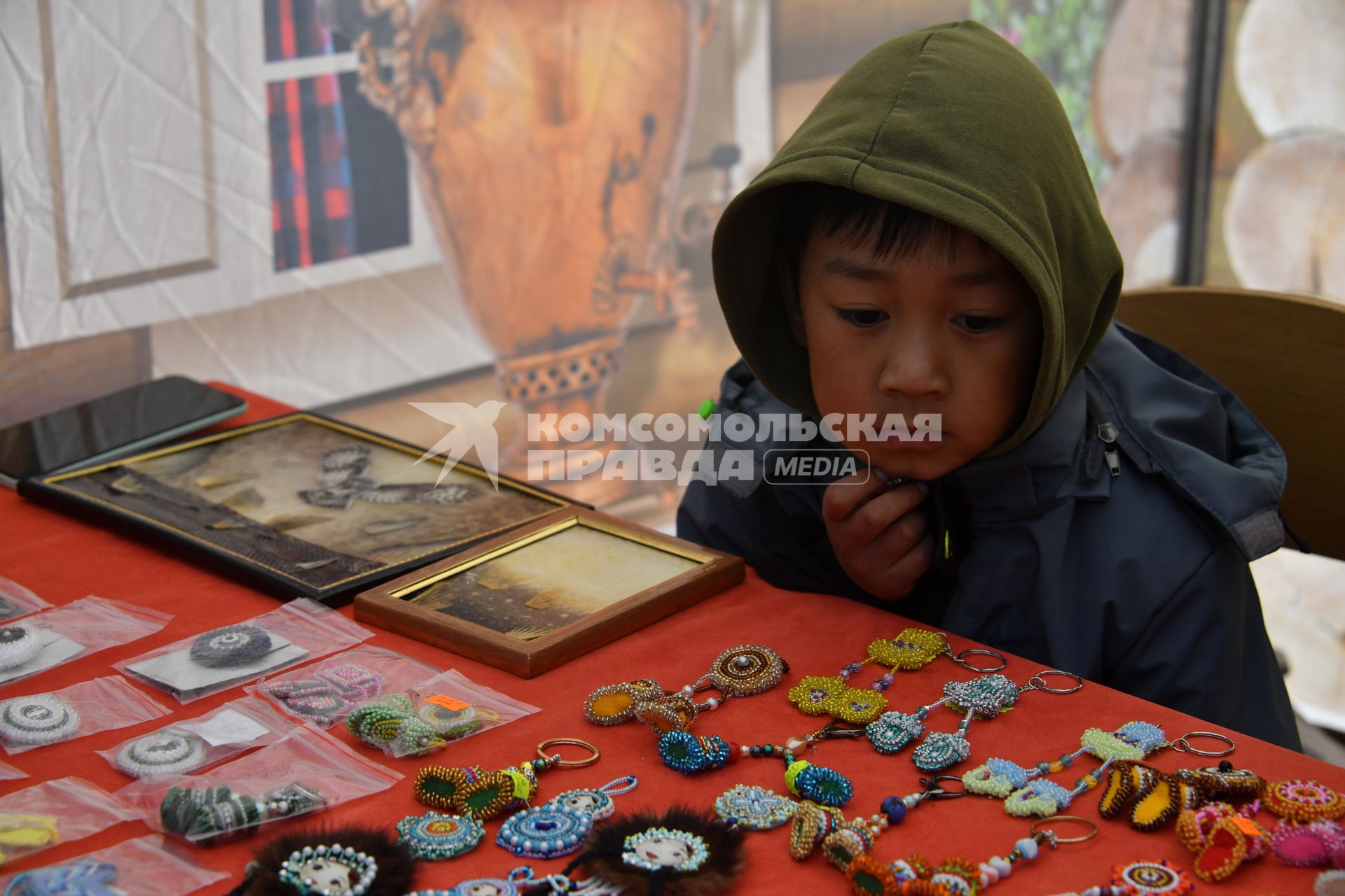 Красноярский край. Хатанга.   Мальчик рассматривает национальные украшения из бисера на празднике День оленевода.