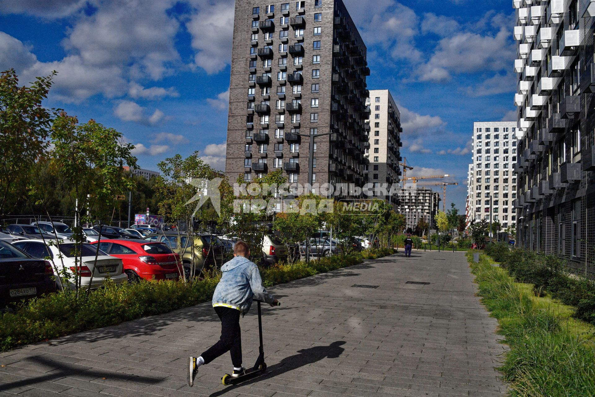 Москва.  Мальчик на самокате во дворе жилого комплекса.