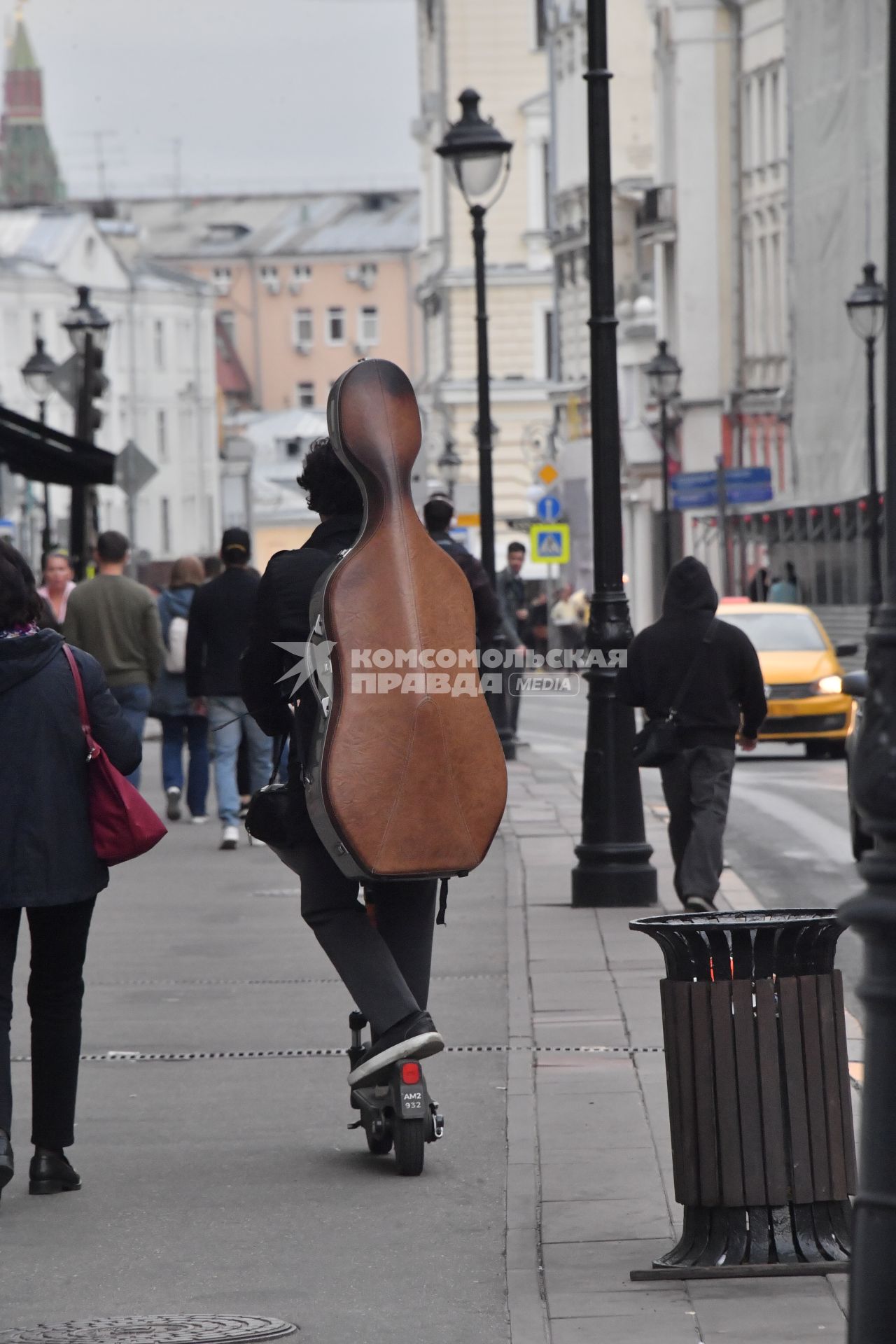 Москва.  Молодой человек едет на самокате.