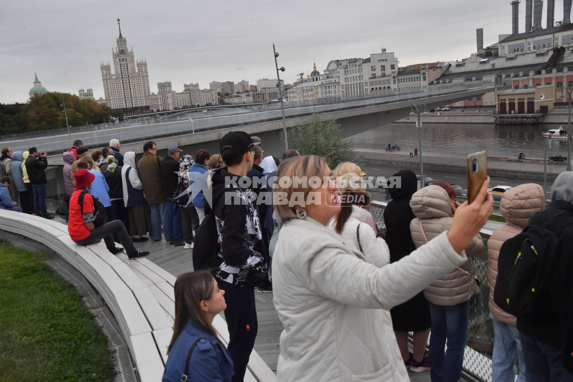 Москва. Прохожие на набережной фотографируют парад теплоходов в честь Дня города на Москве-реке.