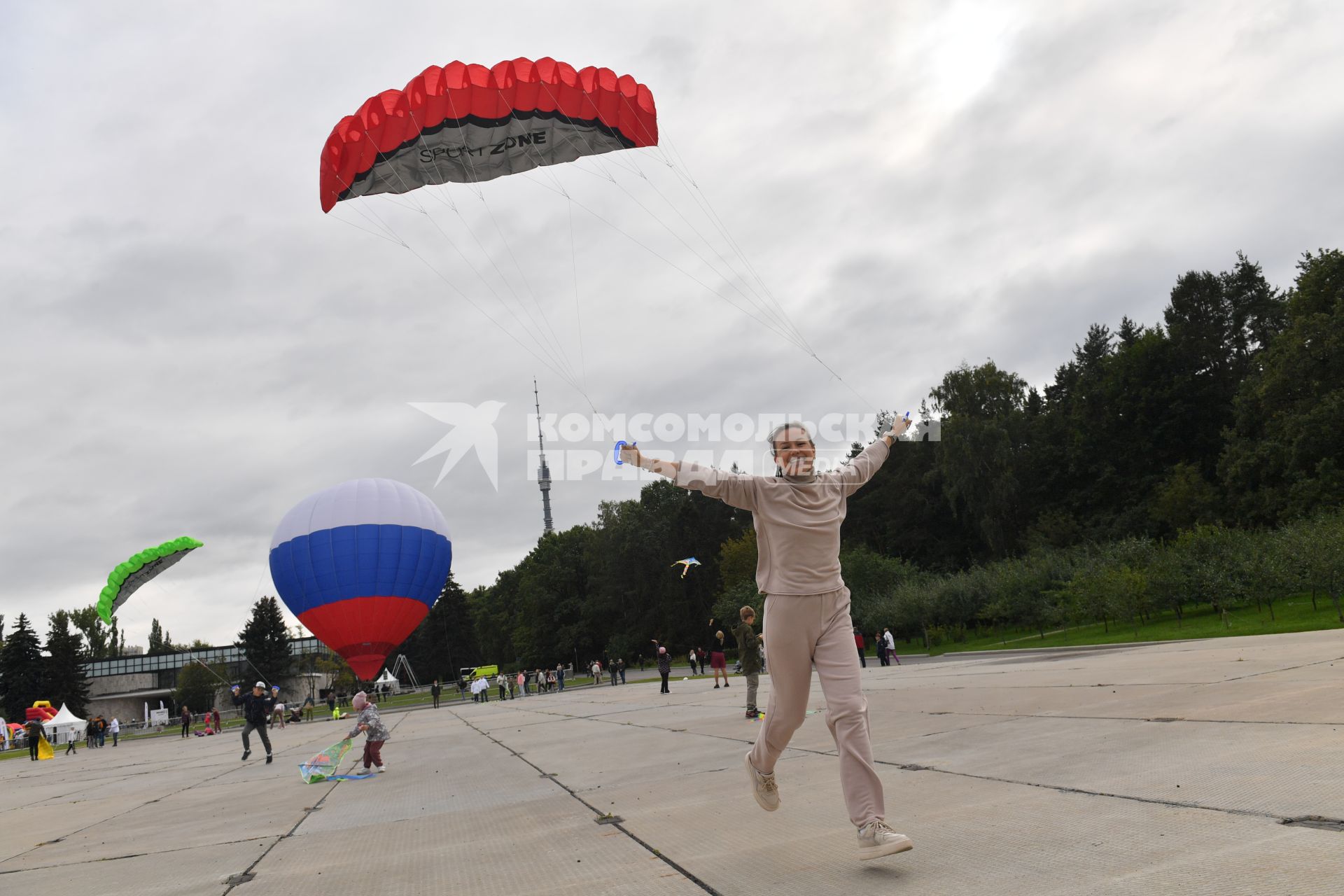 Москва.   Празднование Дня города Москвы на ВДНХ. Мужчина запускает воздушного змея.