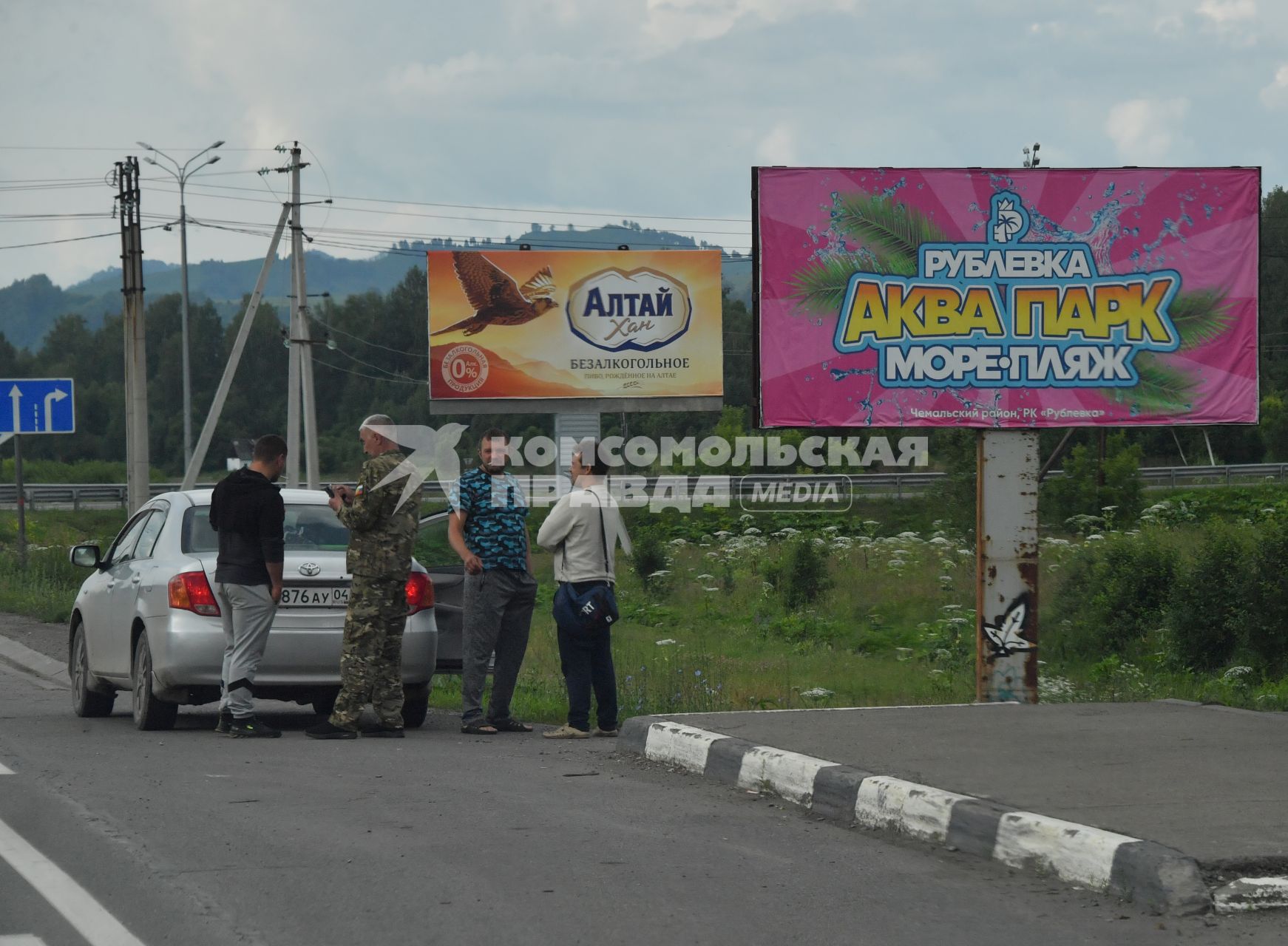 Республика Алтай. Водители стоят у рекламных щитов на федеральной трассе   `Чуйский тракт`.