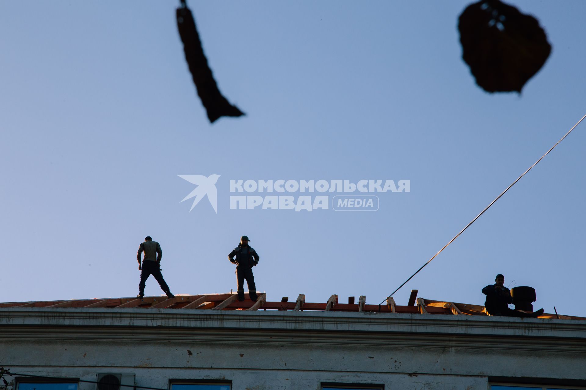 Донецкая область. г.Мариуполь. Рабочие ремонтируют крышу здания.
