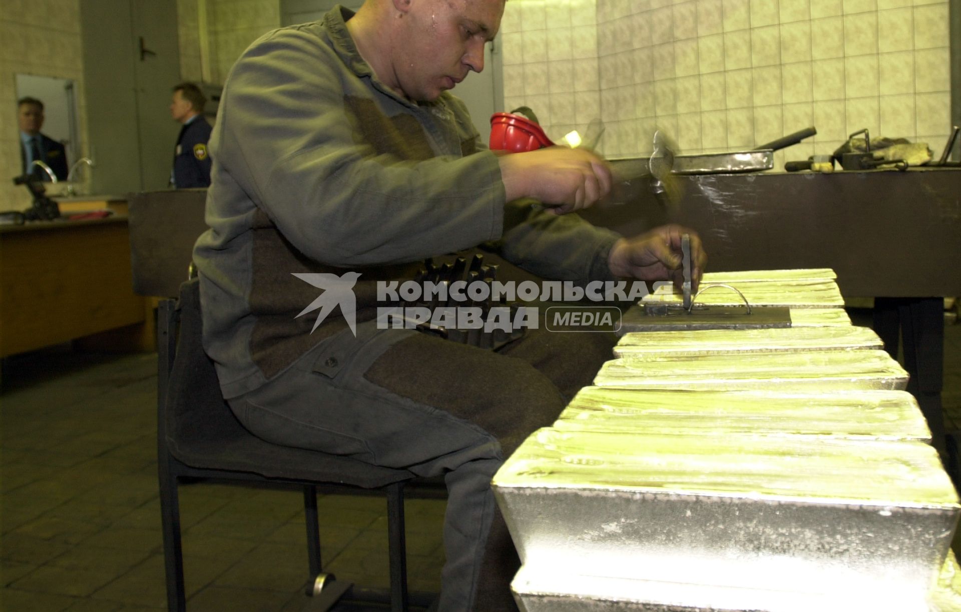 Новосибирск. Сотрудник обрабатывает золотые слитки на Новосибирском аффинажном заводе.