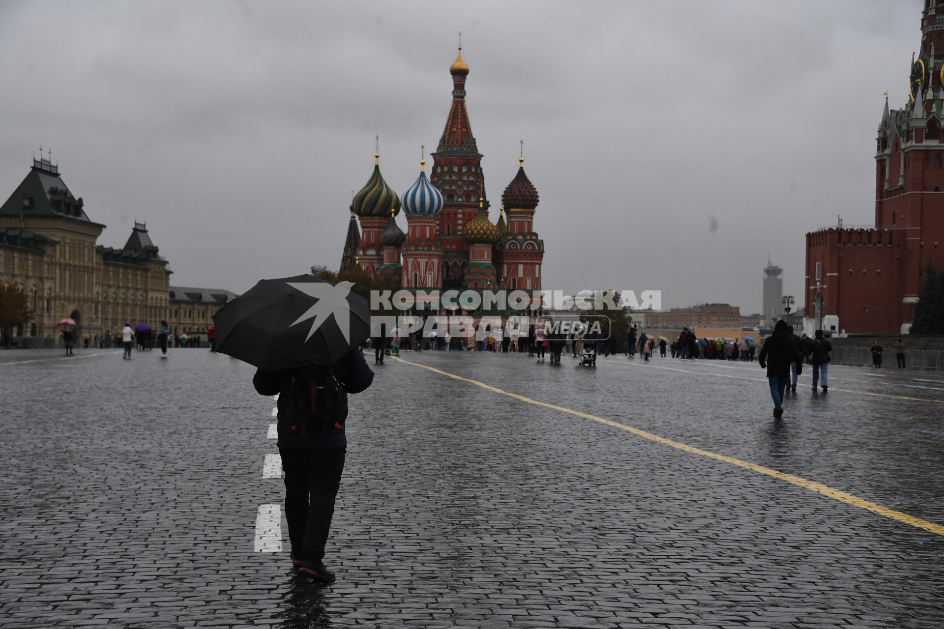 Москва.  Прохожие  на Красной площади во время дождя.