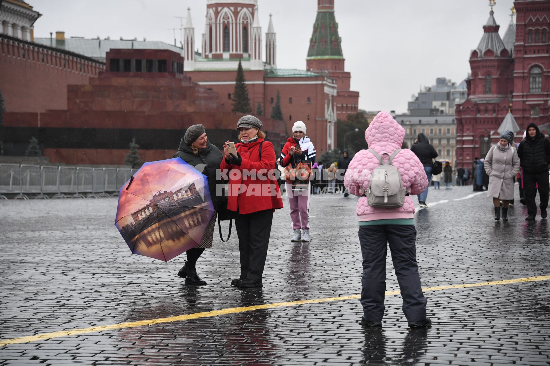 Москва.  Прохожие  на Красной площади во время дождя.