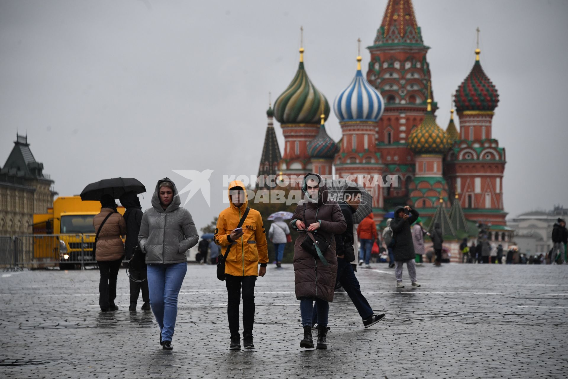 Москва.  Прохожие  на Красной площади во время дождя.