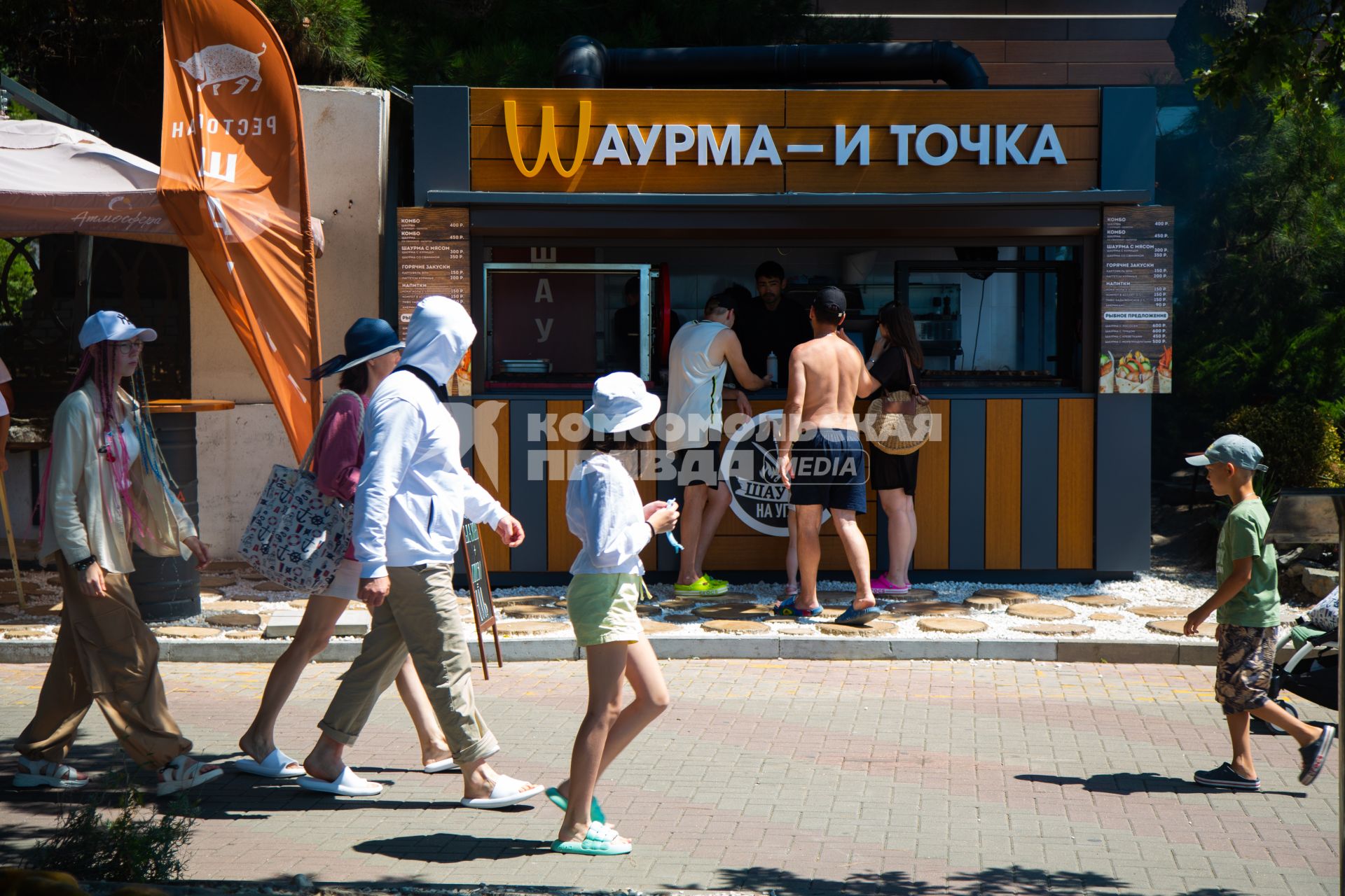 Геленджик. Люди покупают шаурму в киоске с надписью `Шаурма и точка`.