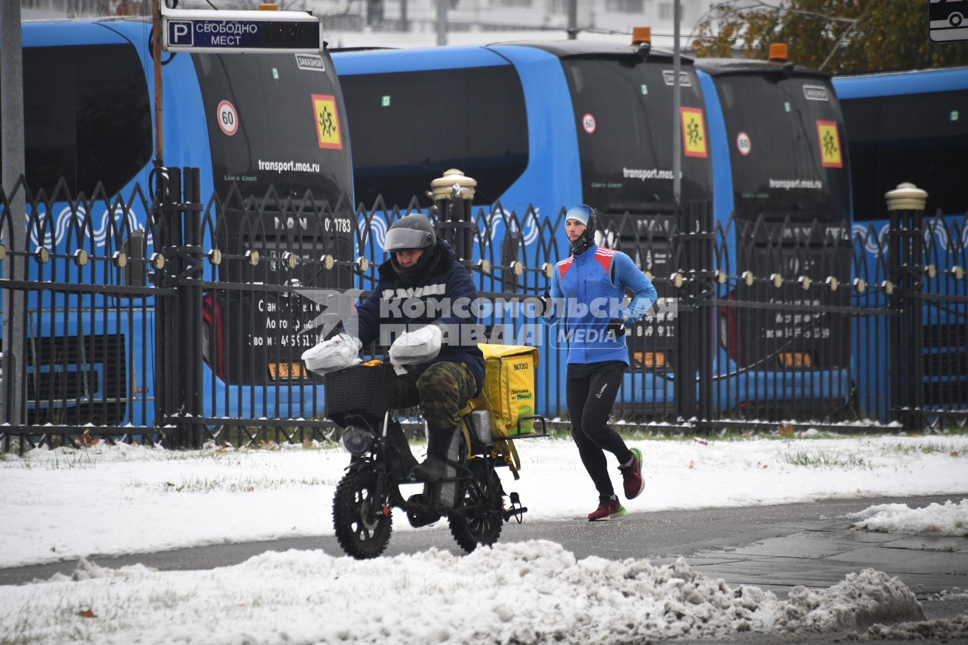Москва. Доставщик еды едет на скутере.