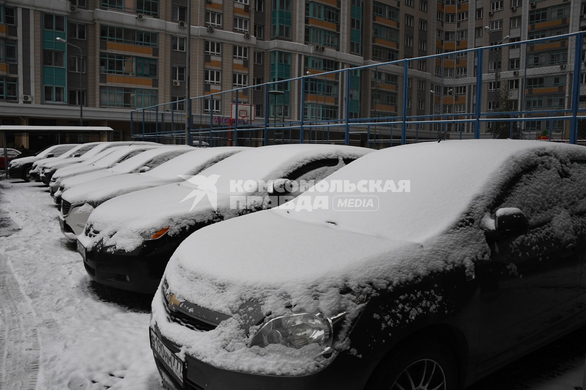 Москва. Заснеженные припаркованные автомобили во вдоре.