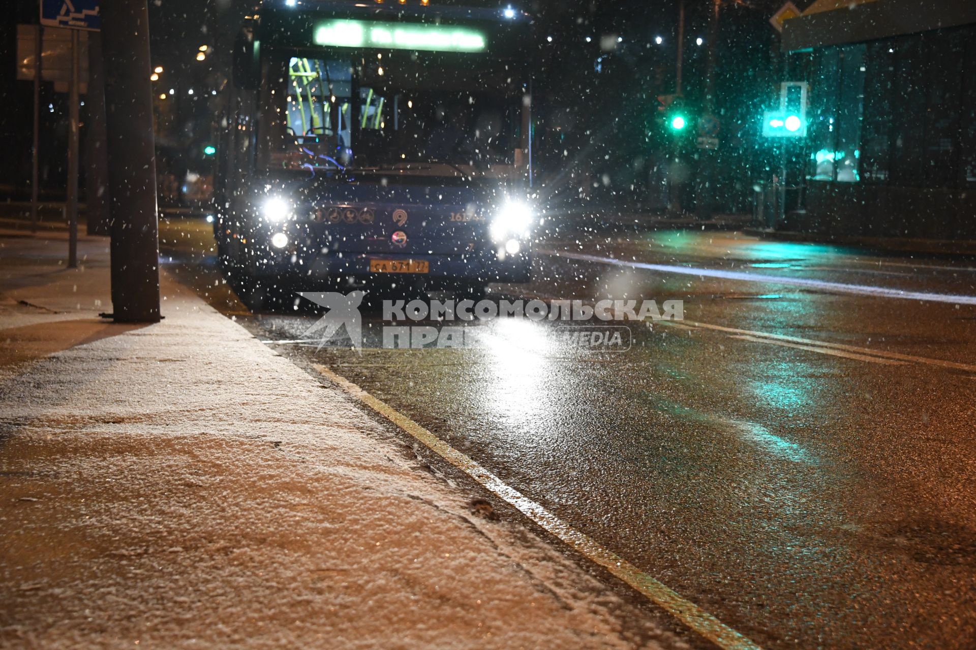 Москва. Автобус движется по вечерней улице во время снегопада.