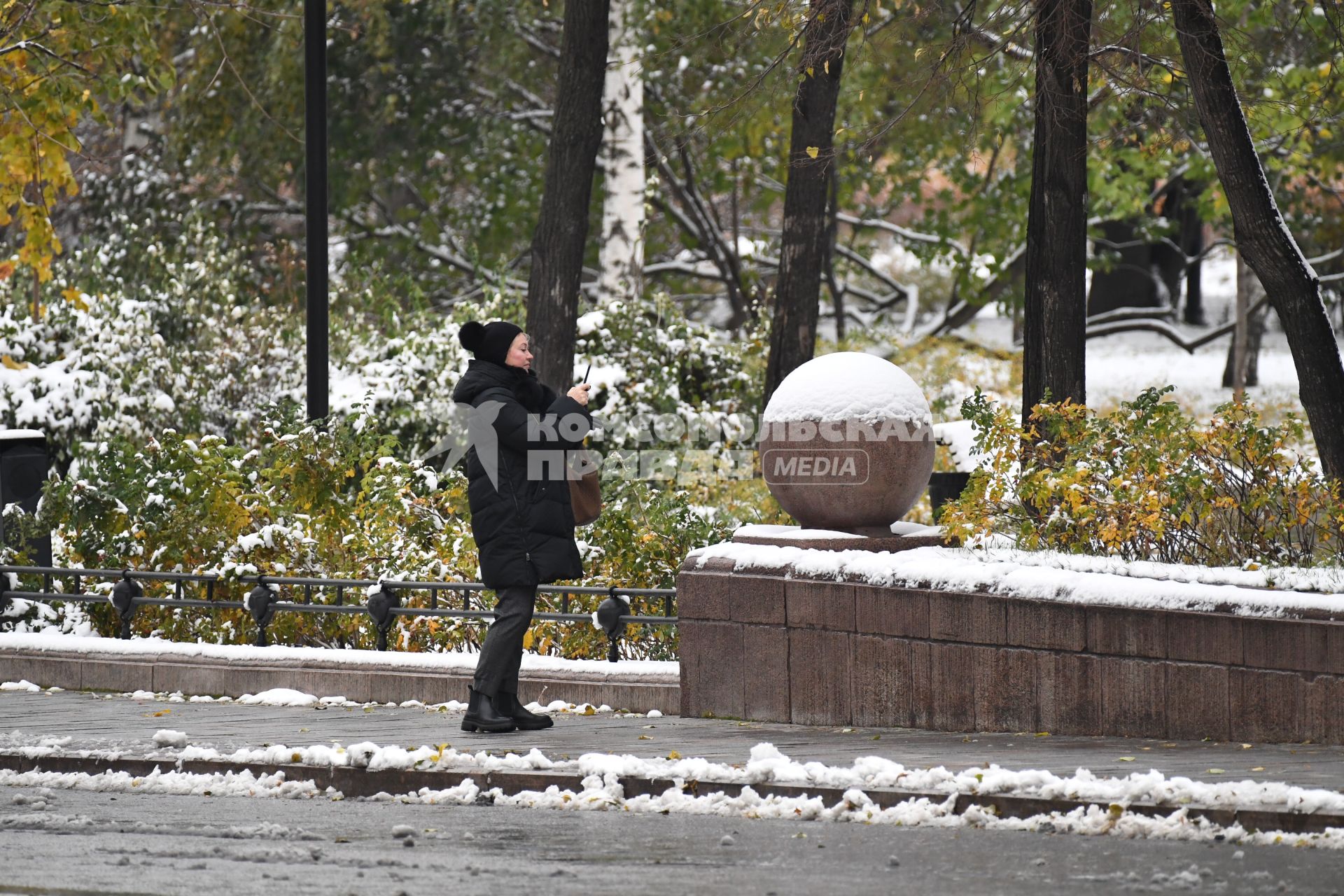 Москва. Женщина фотографирует на улице.